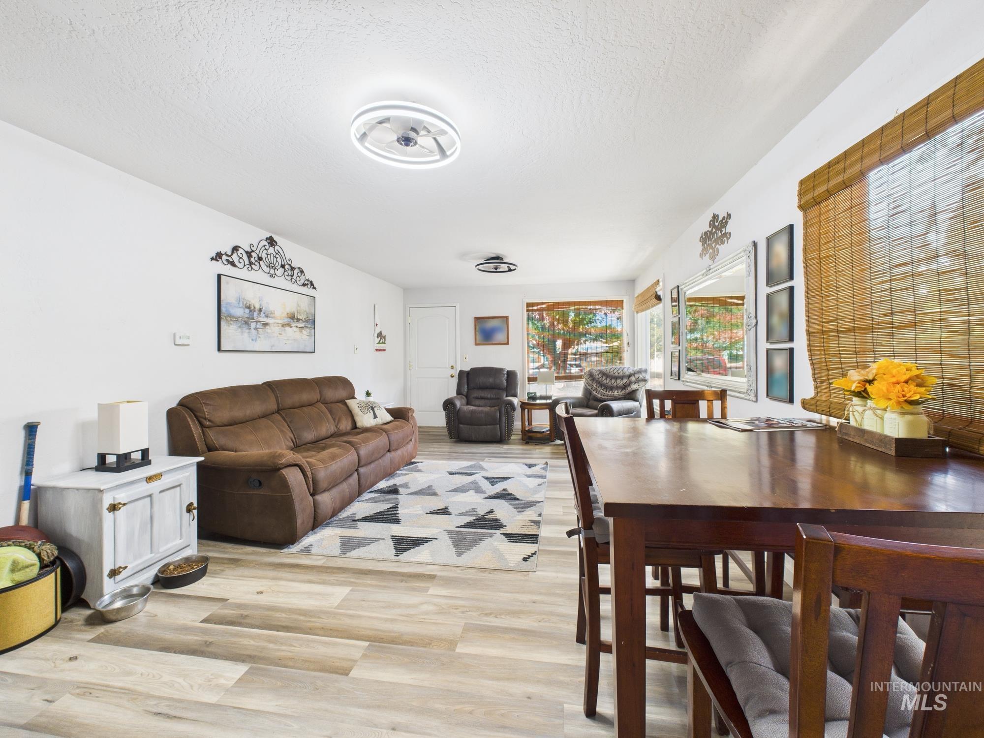 Living area featuring light wood finished floors and a textured ceiling