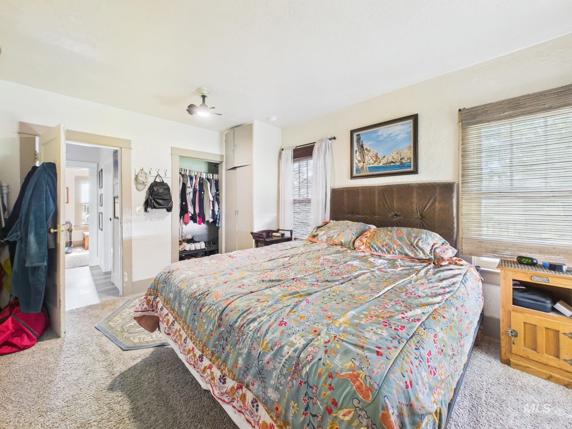 Carpeted bedroom featuring a closet and ceiling fan