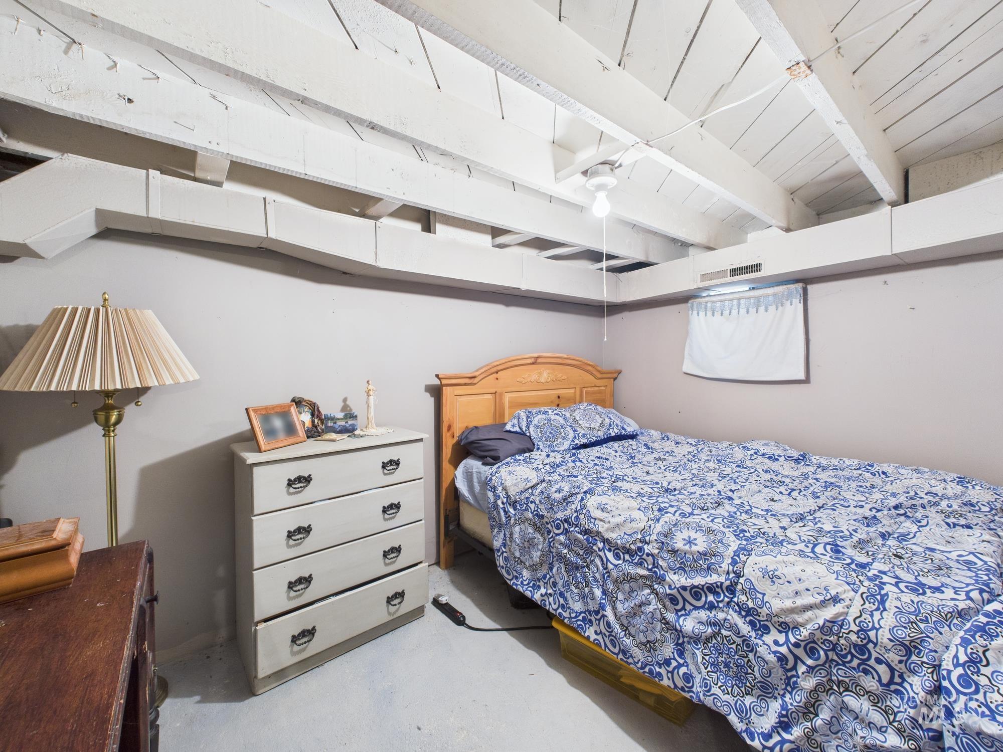 Bedroom featuring beam ceiling and concrete flooring