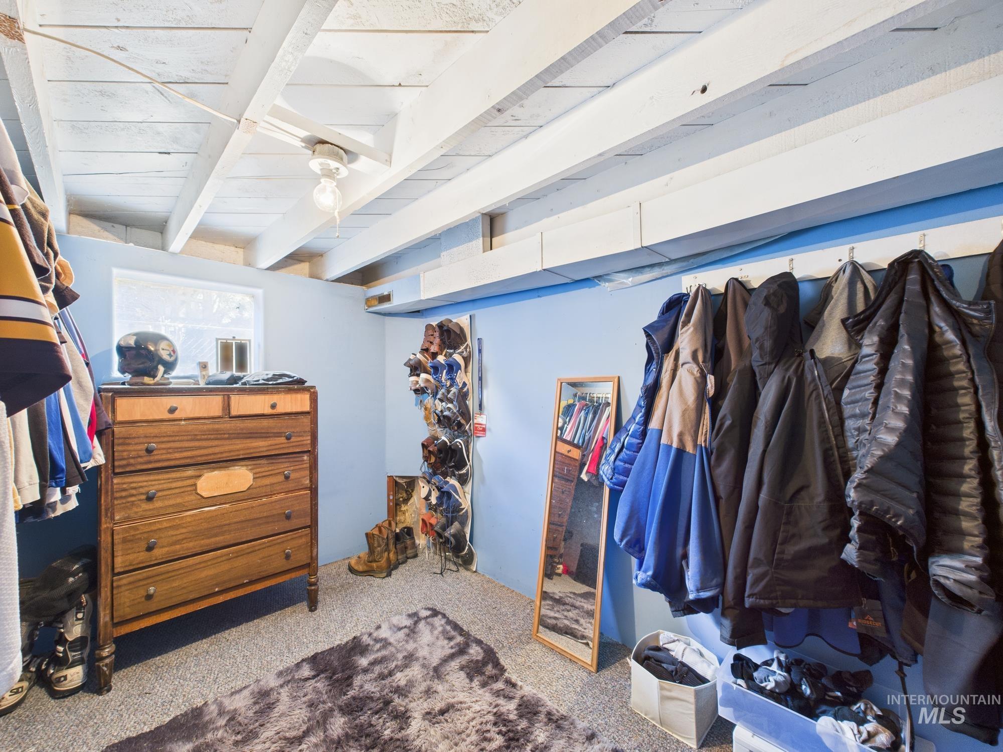 Walk in closet with carpet floors and beam ceiling