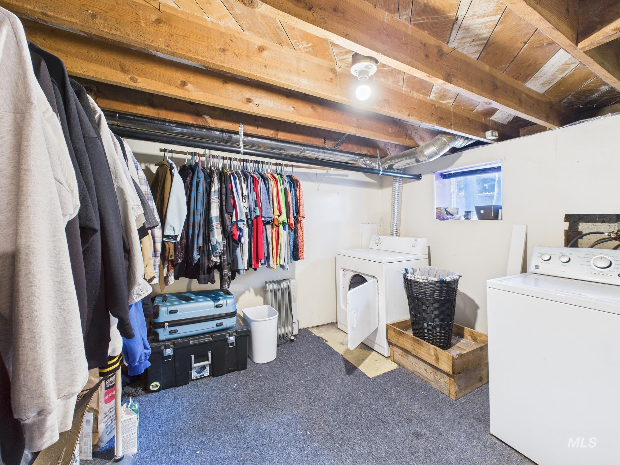 Laundry area with washer and dryer, radiator, and carpet floors