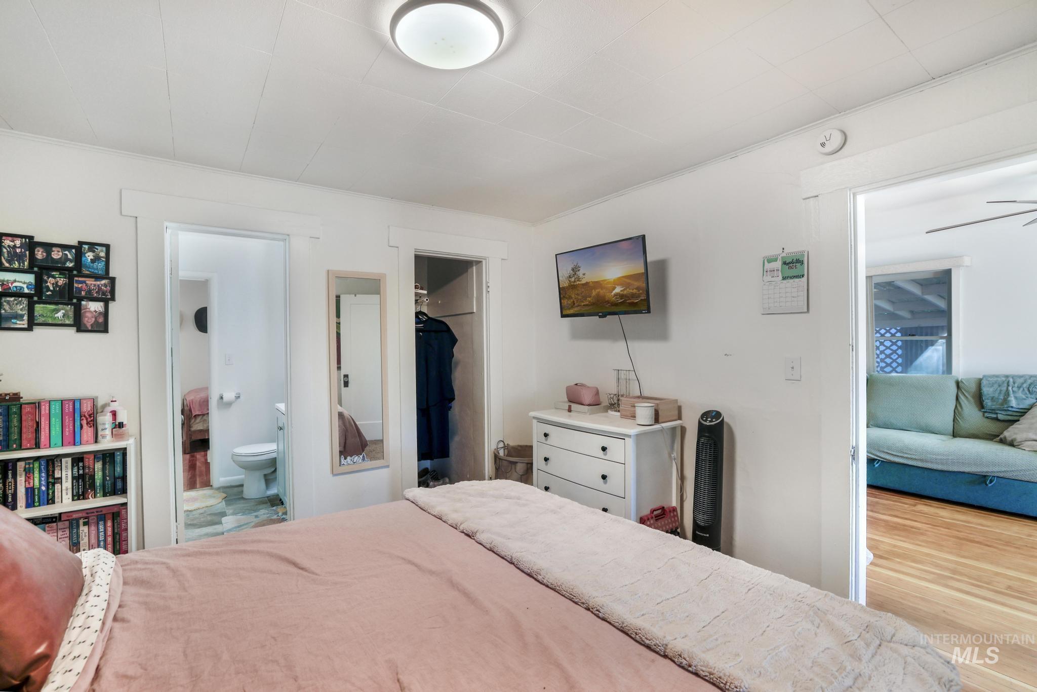 Bedroom with a spacious closet and wood finished floors