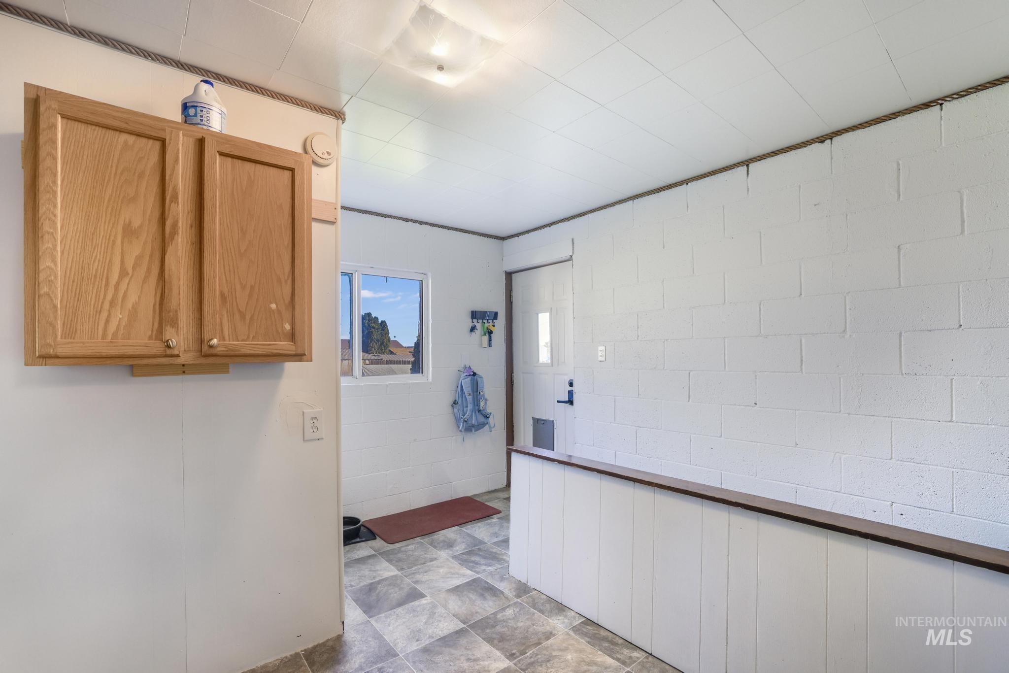 Kitchen with concrete block wall and brown cabinetry
