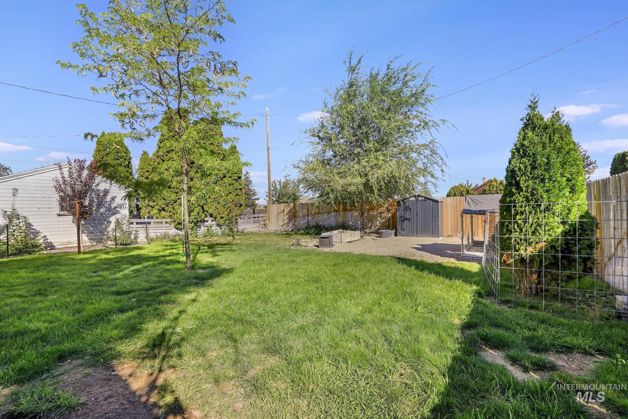 Fenced backyard with a patio area and a shed