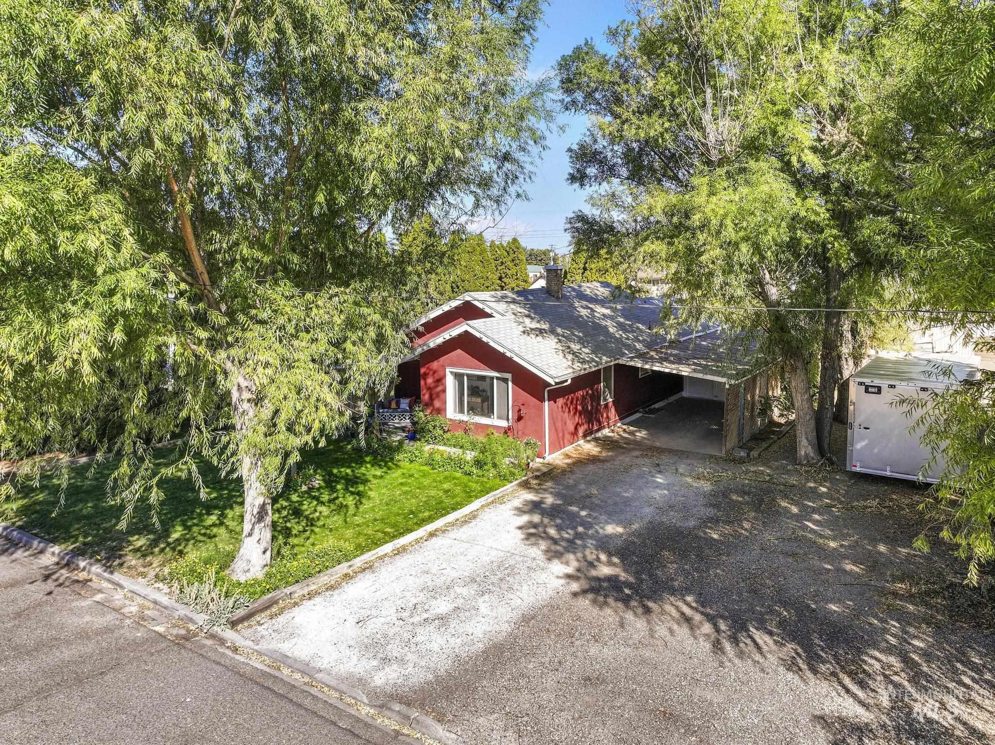 View of front of property with a carport, driveway, a front lawn, and a chimney