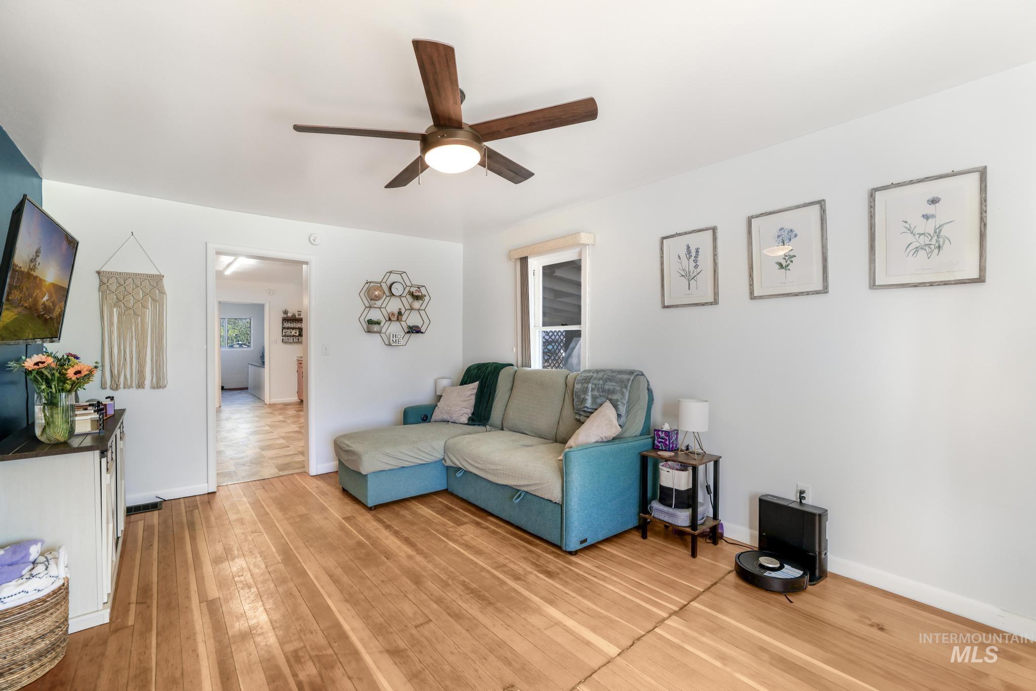 Living room featuring light wood-style flooring and ceiling fan