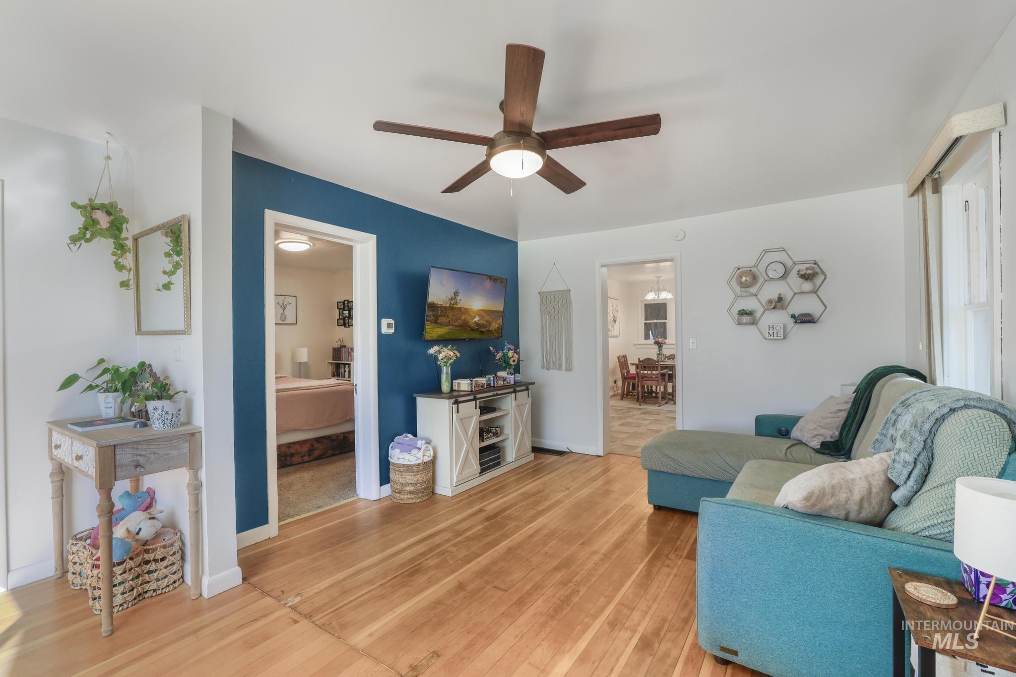 Living area with light wood-style floors and ceiling fan