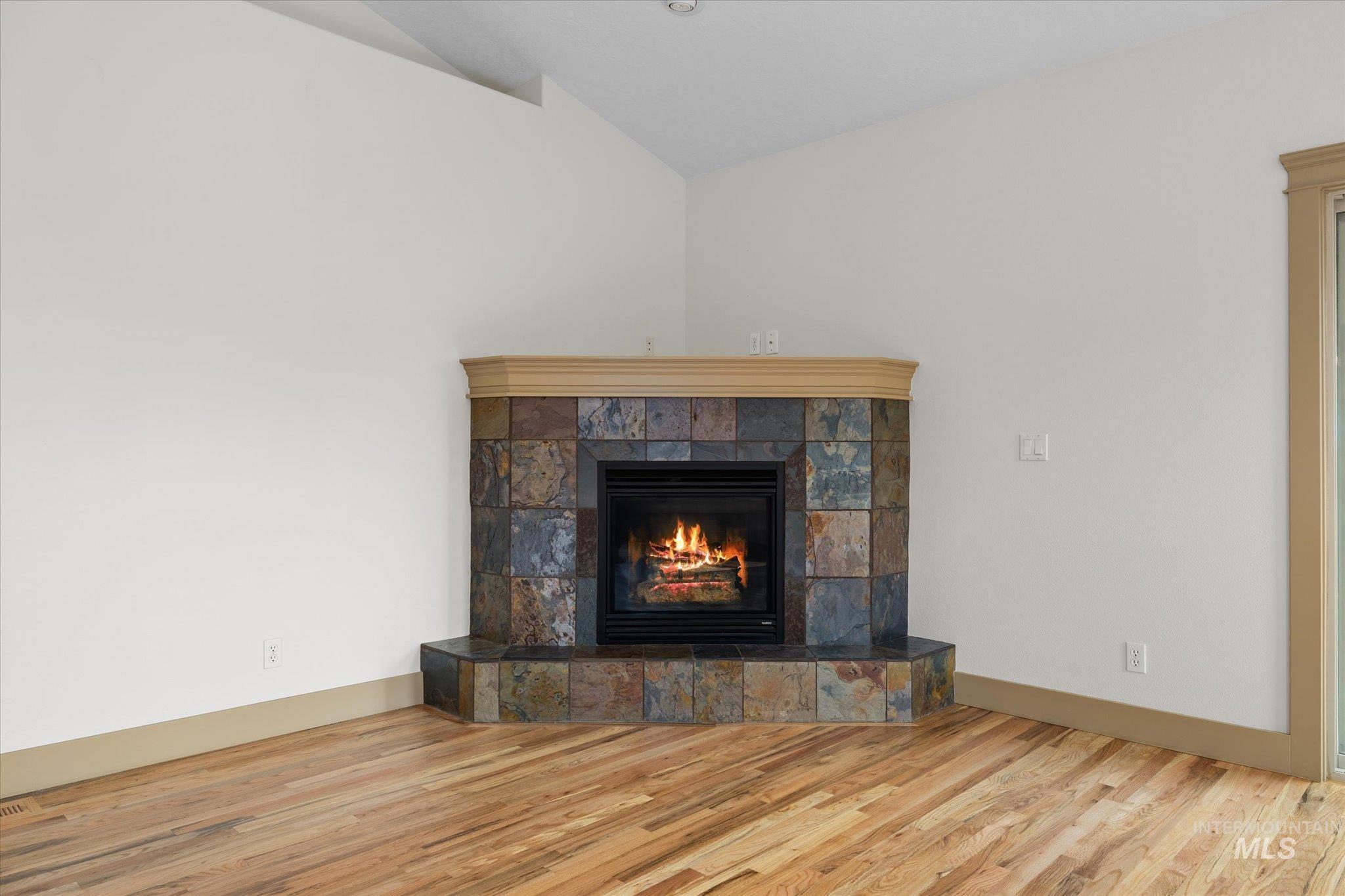 Detailed view of a tile fireplace and wood finished floors