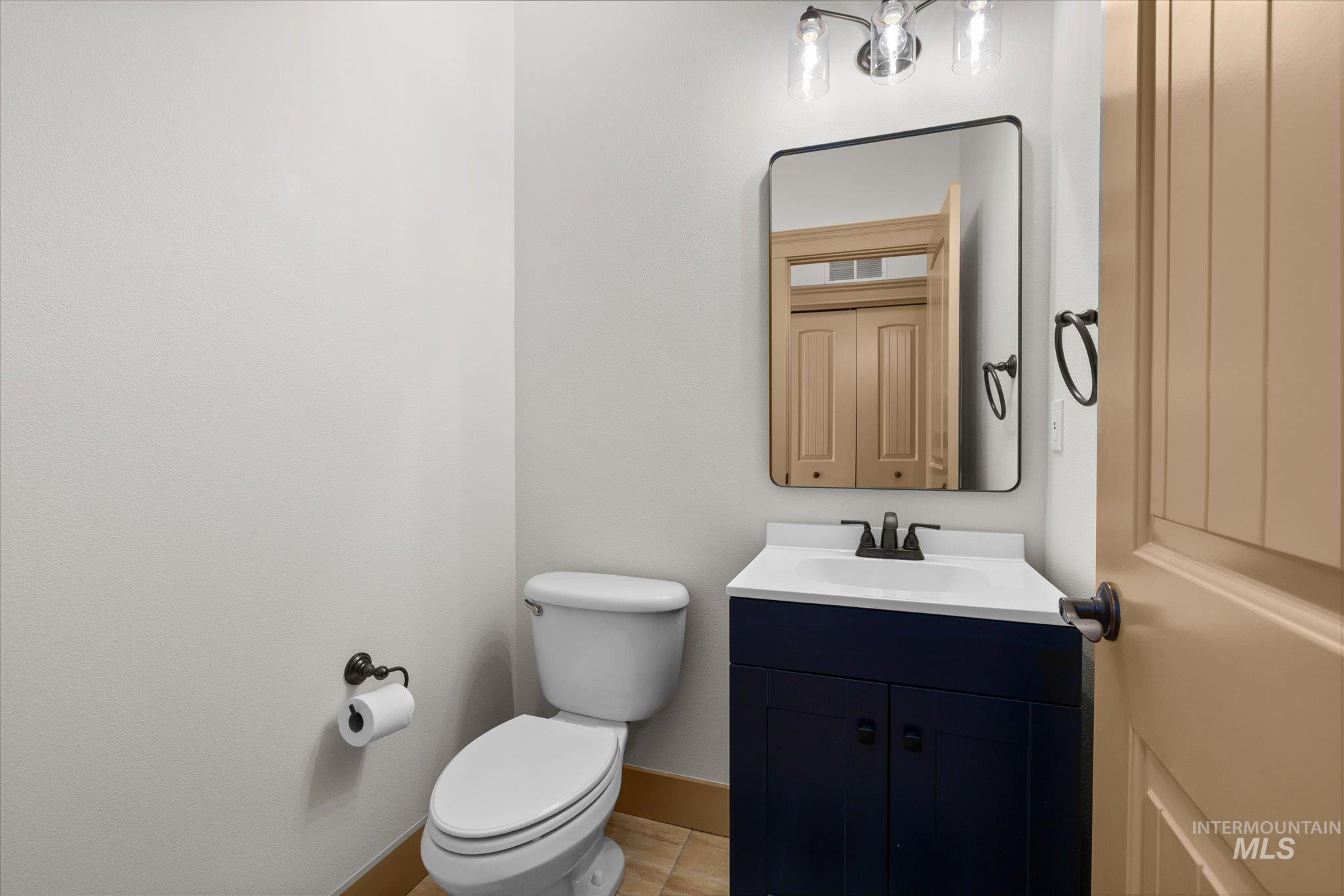 Half bathroom with vanity and toilet