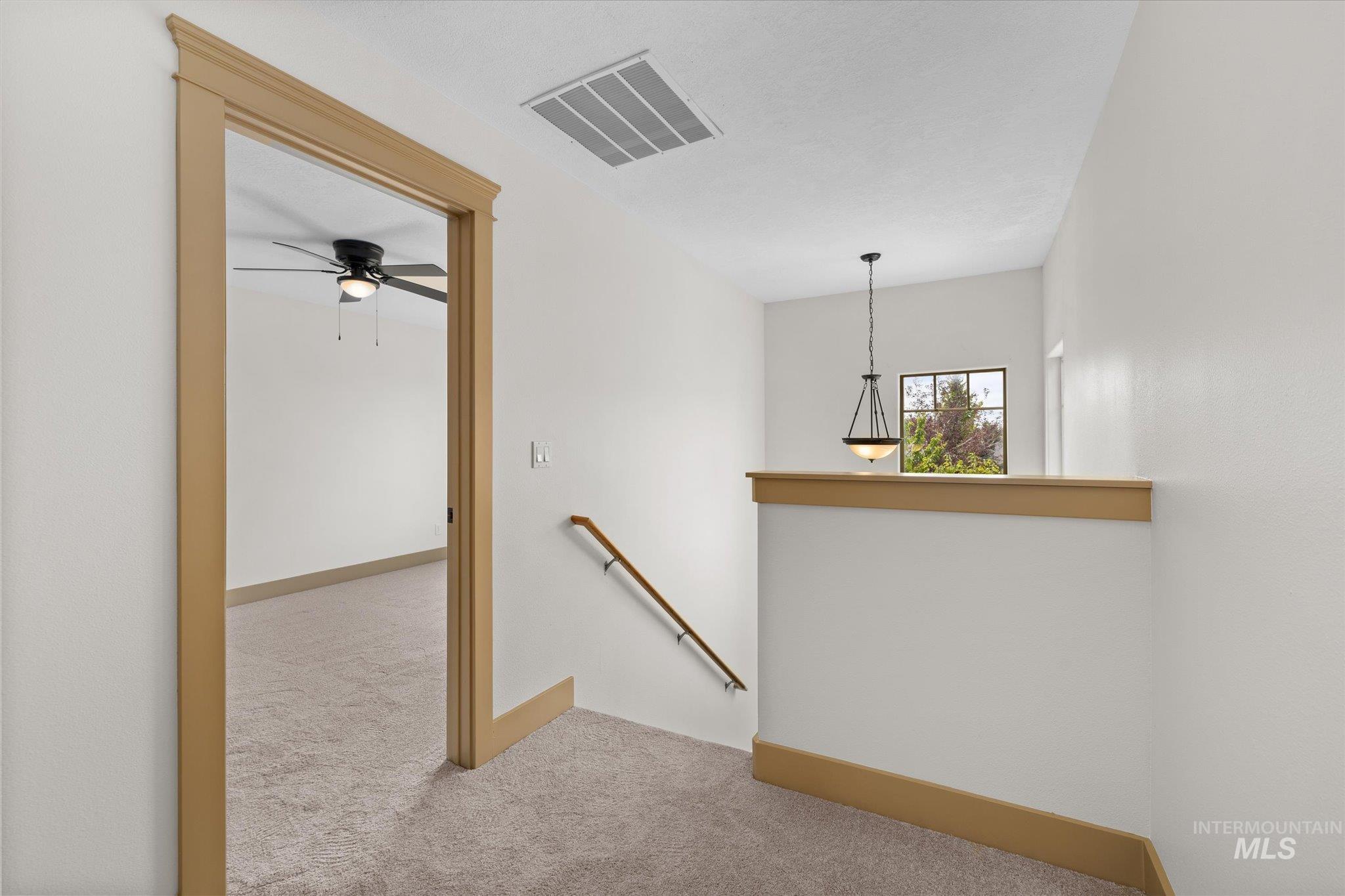 Hallway with an upstairs landing and carpet