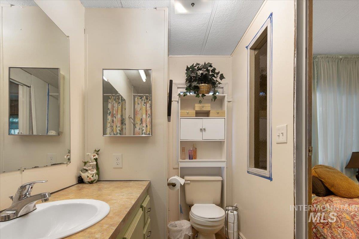 Full bathroom with a textured ceiling and vanity