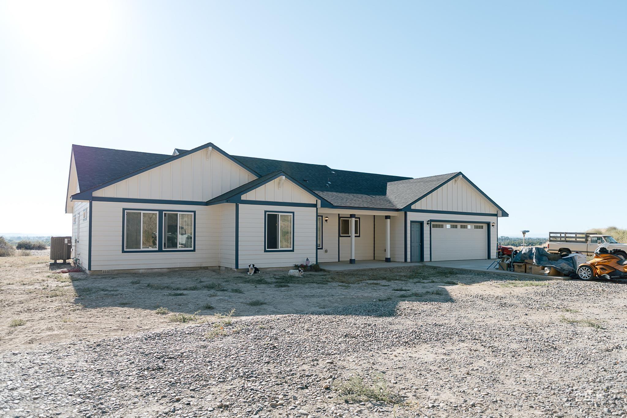 View of front of home featuring board and batten siding, driveway, roof with shingles, and an attached garage