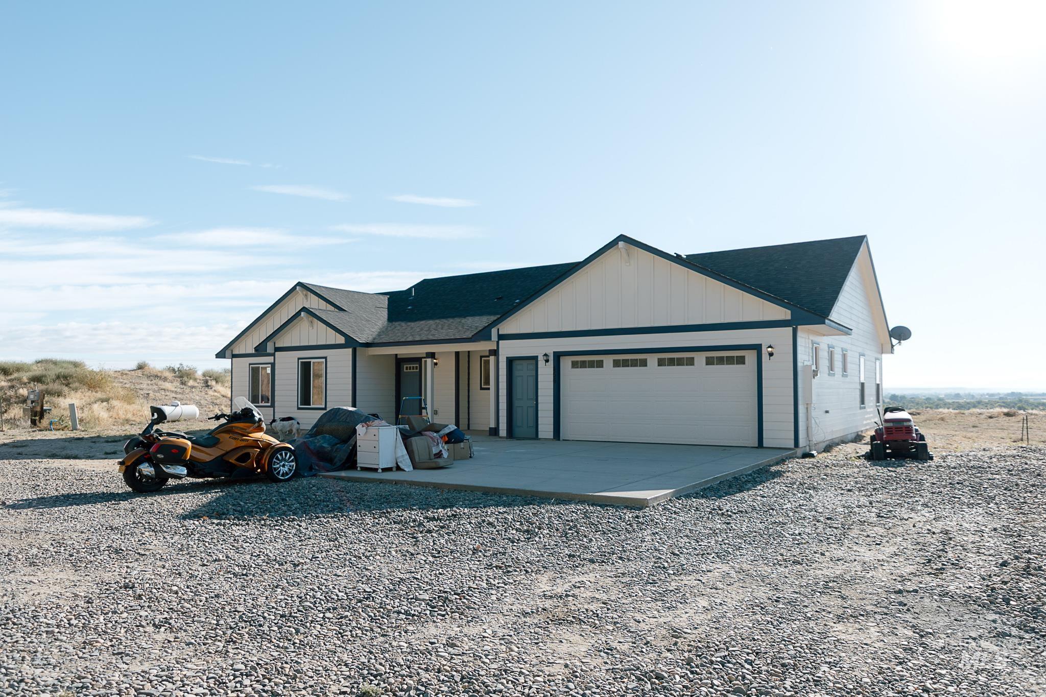 View of front of house featuring board and batten siding, driveway, an attached garage, and a porch