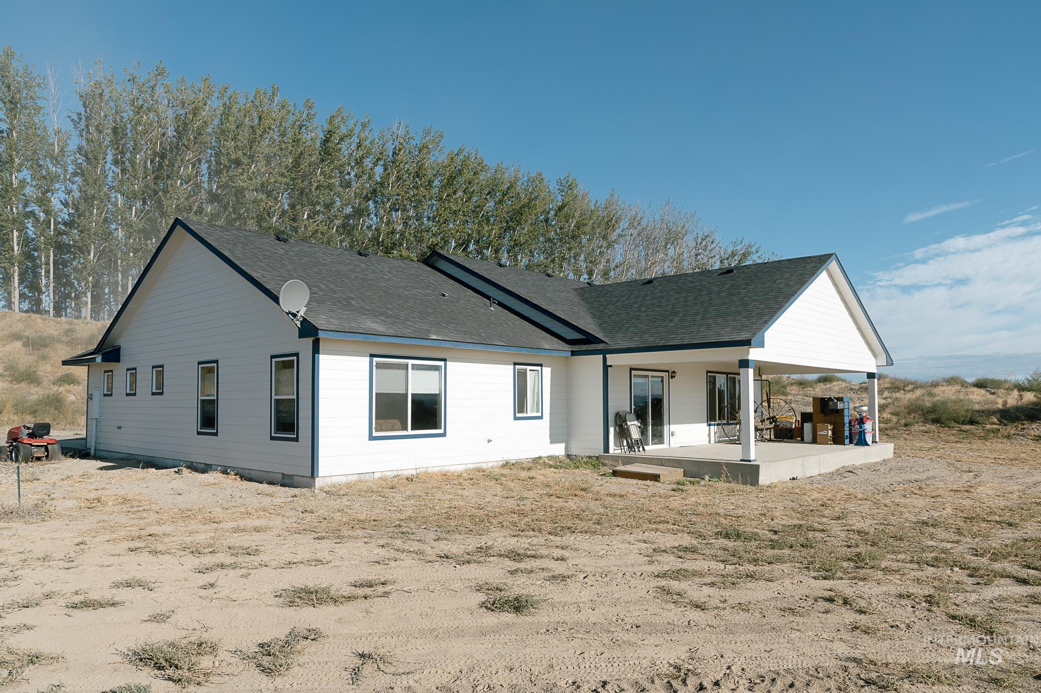 Back of property with roof with shingles and a patio area