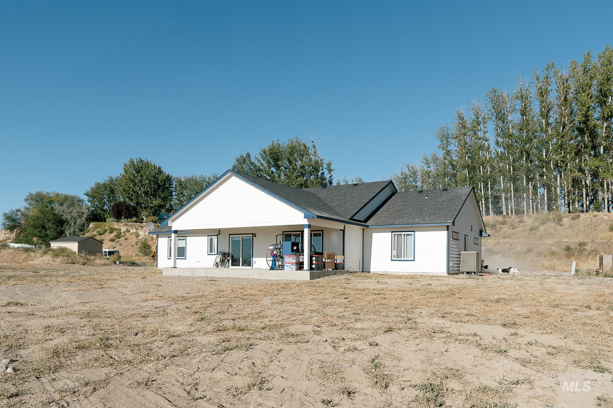 Rear view of property with a patio and roof with shingles