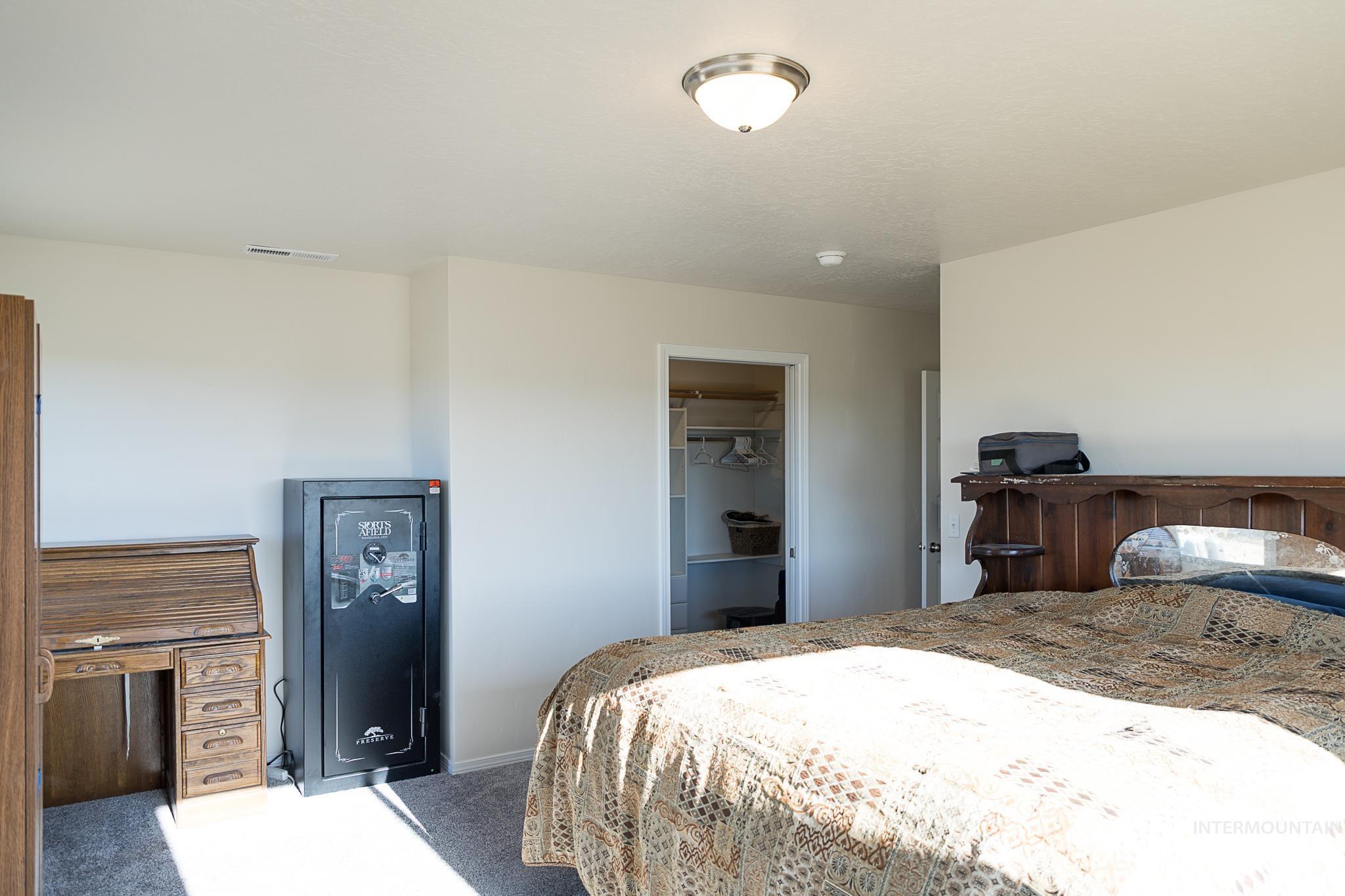 Carpeted bedroom featuring a spacious closet and baseboards