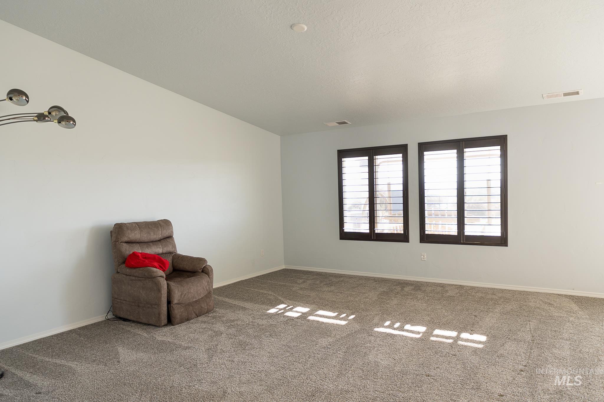 Unfurnished room with carpet flooring and a textured ceiling