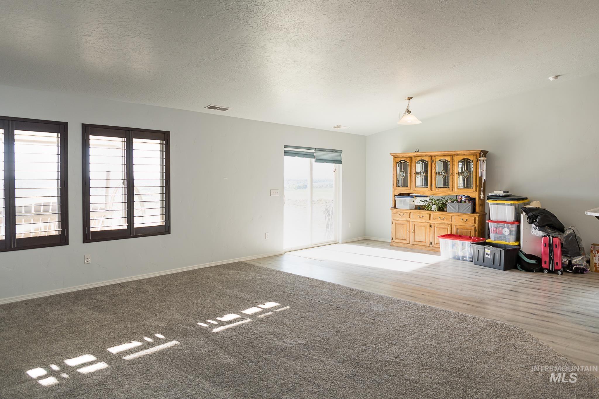 Living area featuring a textured ceiling and baseboards