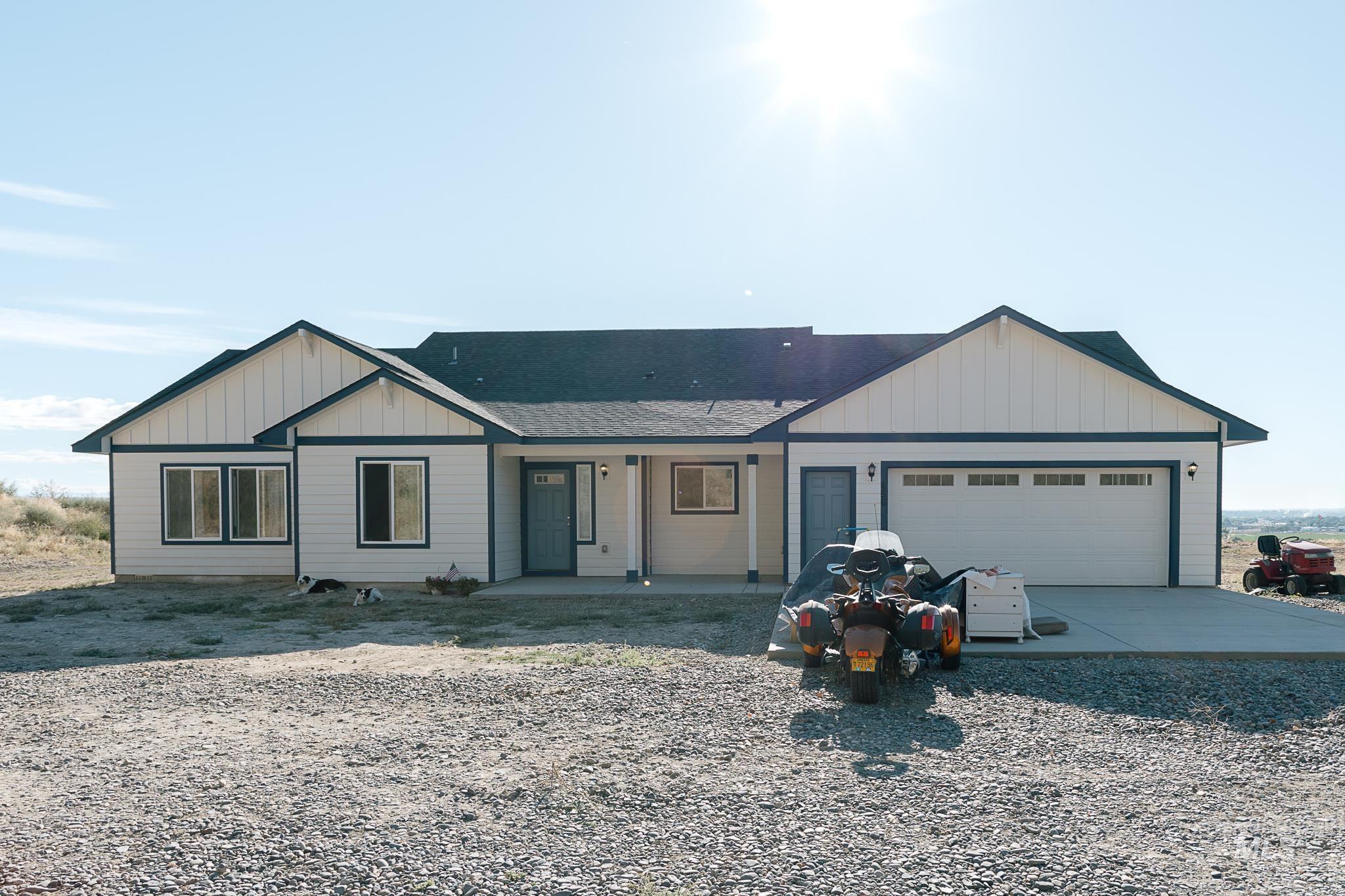 Ranch-style house with board and batten siding, concrete driveway, a shingled roof, and an attached garage