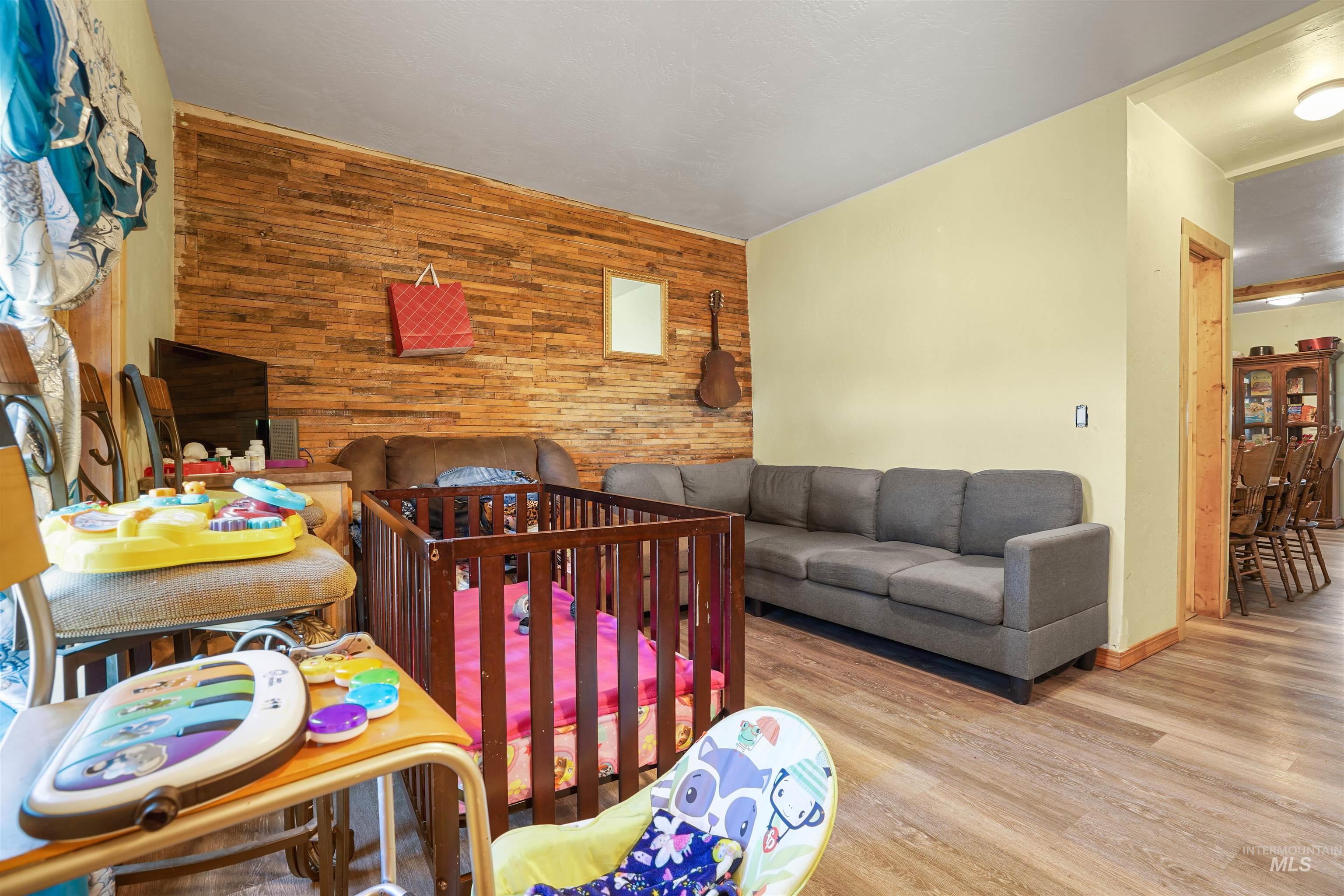 Bedroom featuring wood walls, an accent wall, and wood finished floors