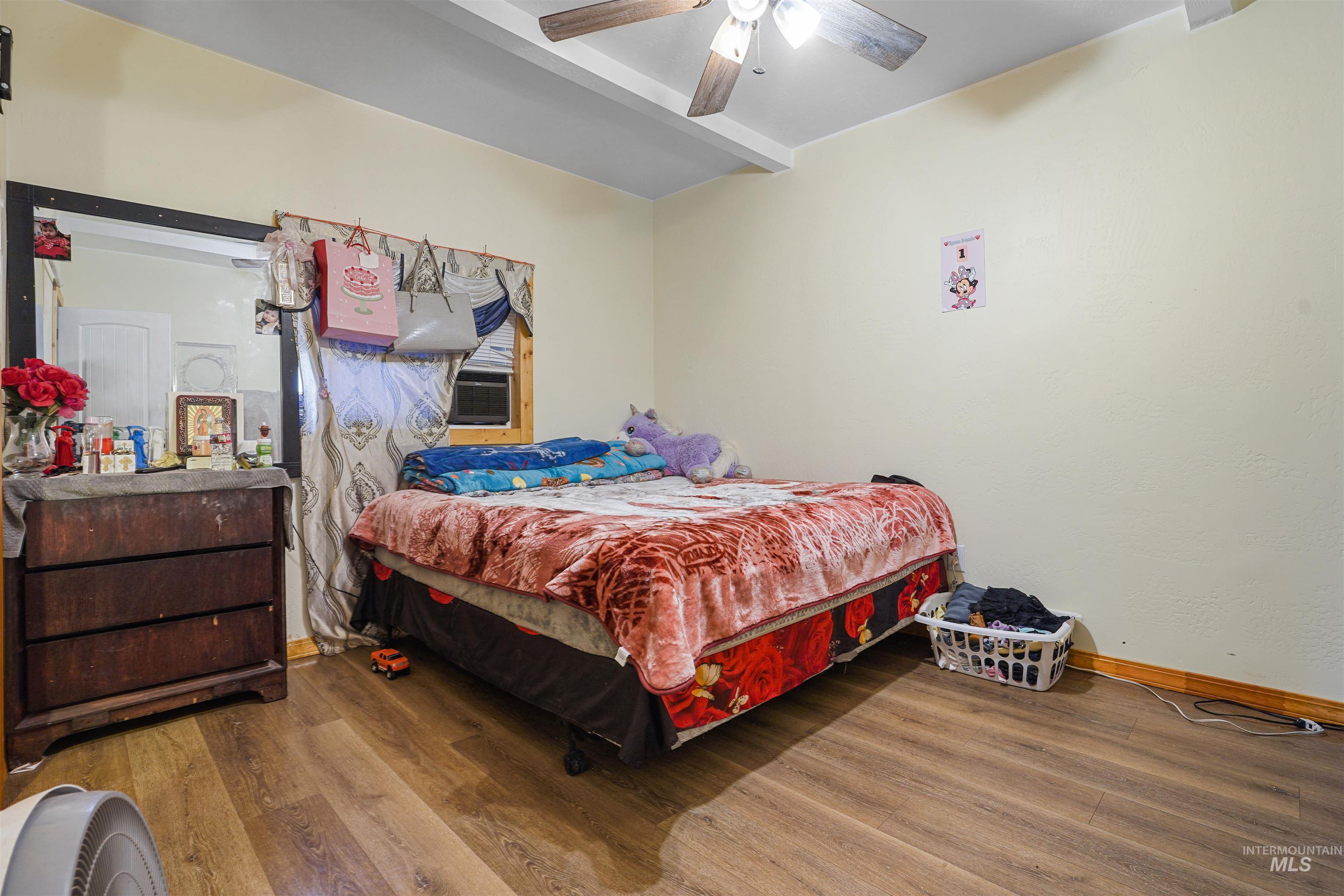Bedroom featuring wood finished floors and a ceiling fan
