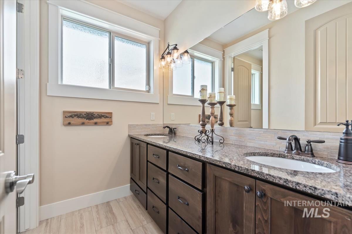 Bathroom featuring a chandelier and double vanity
