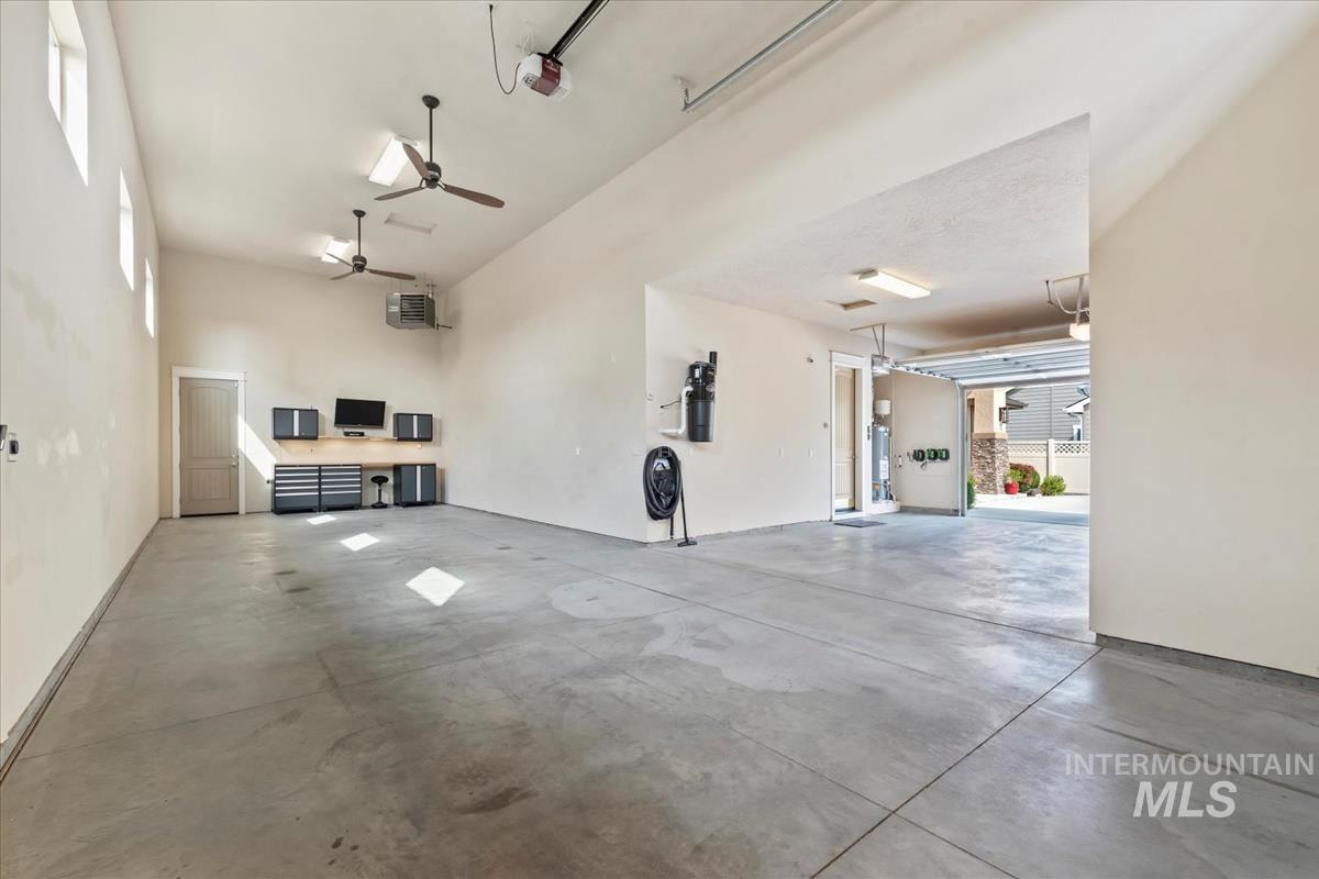 RV garage featuring a heating unit, ceiling fan, and workstation