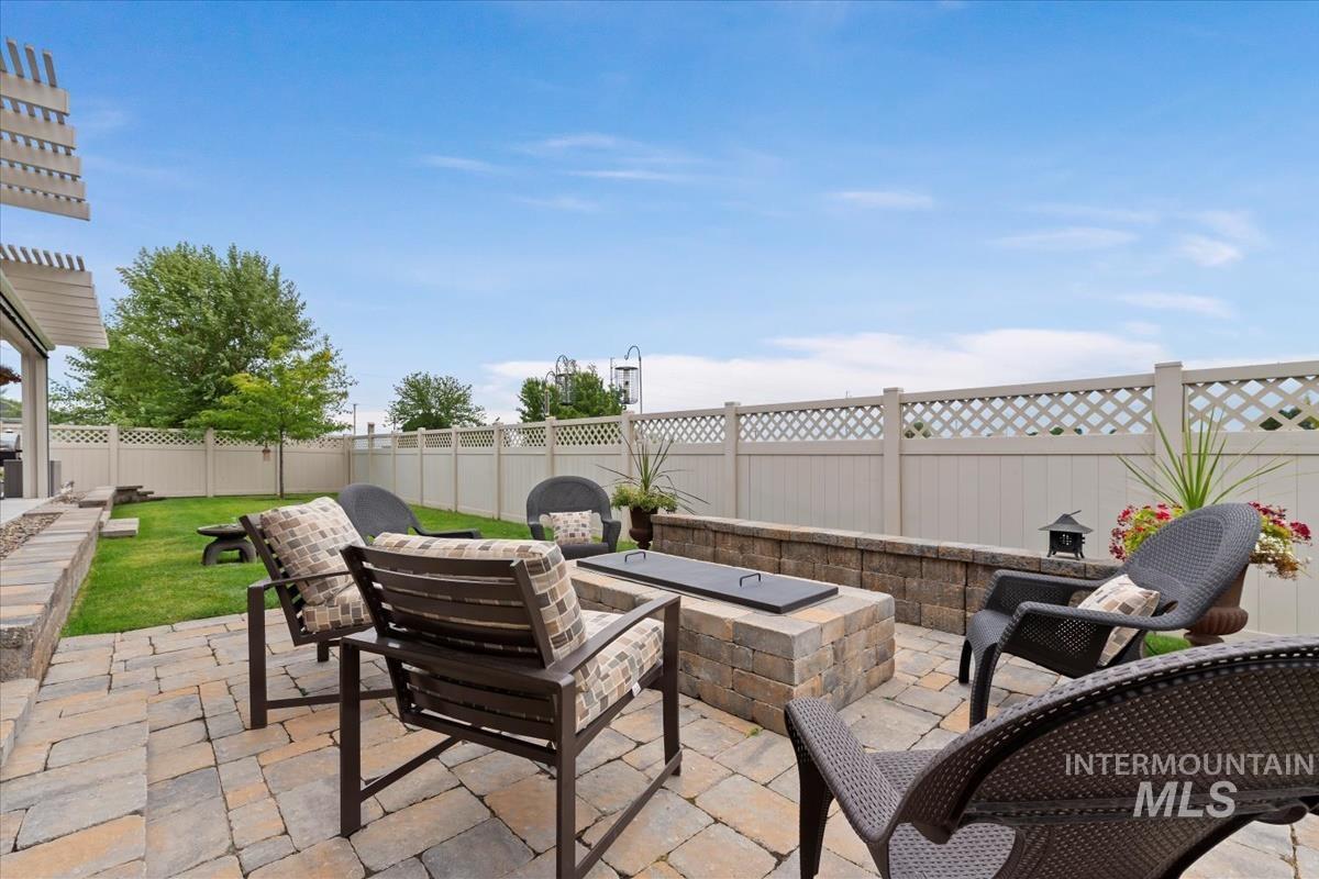 Fenced backyard featuring an outdoor fire pit and a patio