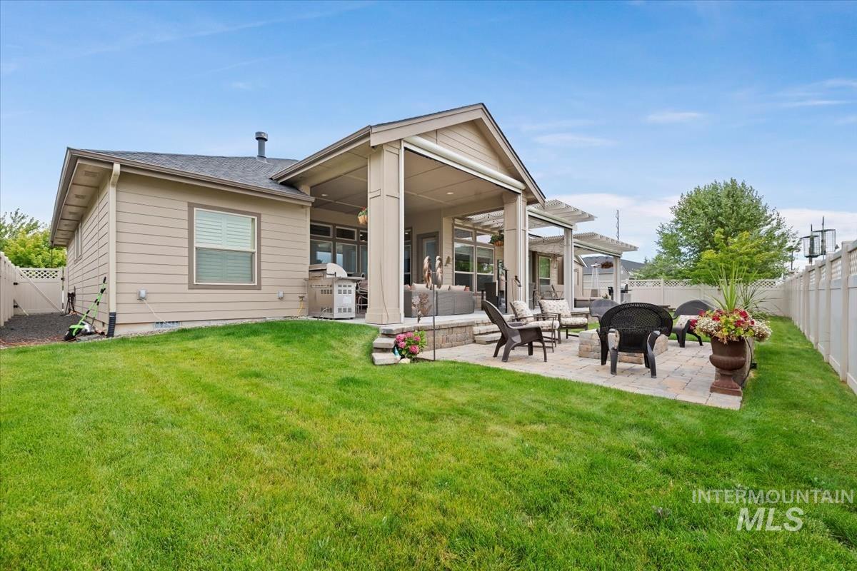 Rear view of property with a fenced backyard, a patio, an outdoor living space, and roof with shingles