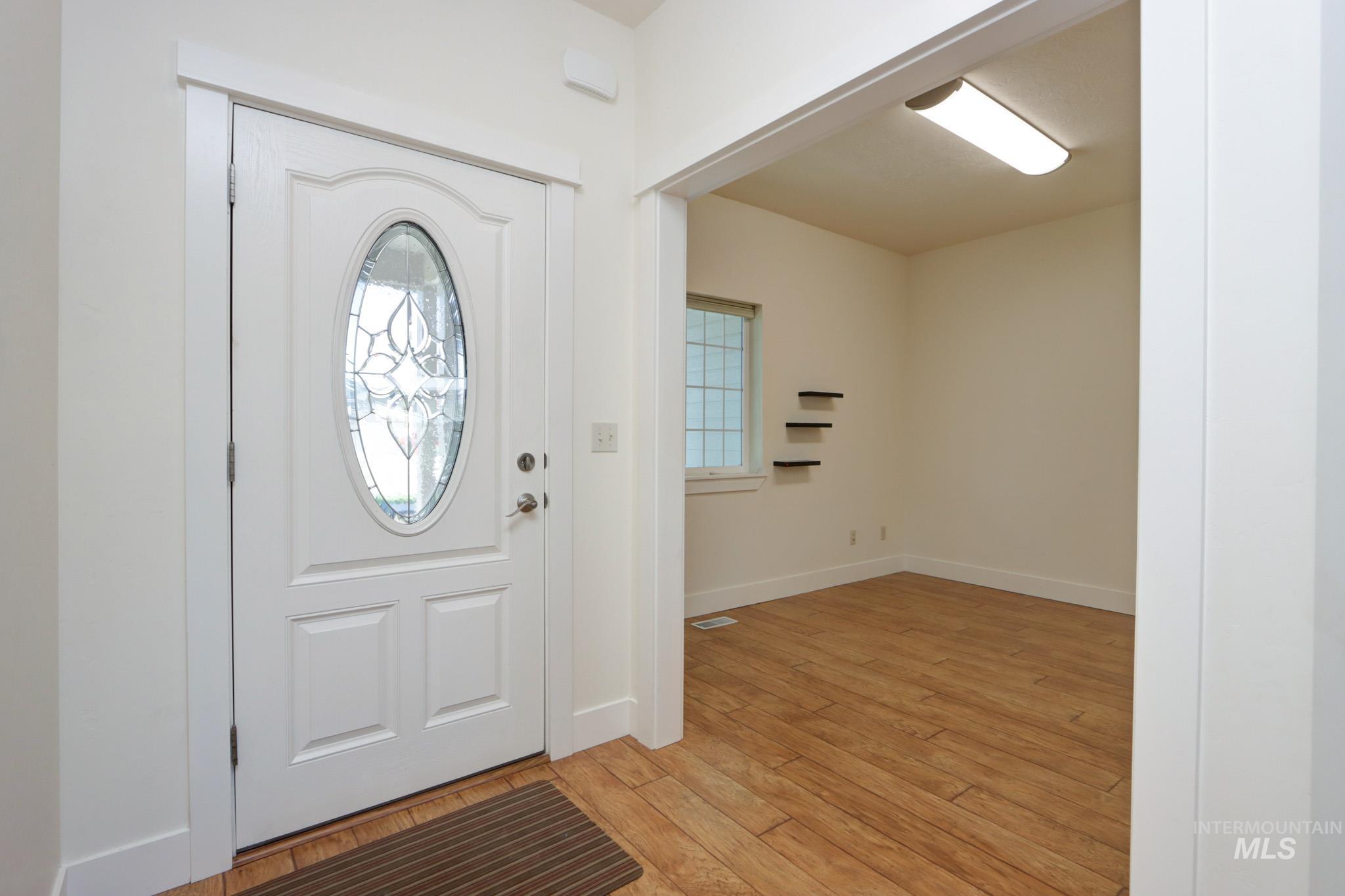 Foyer with light wood-style flooring and baseboards
