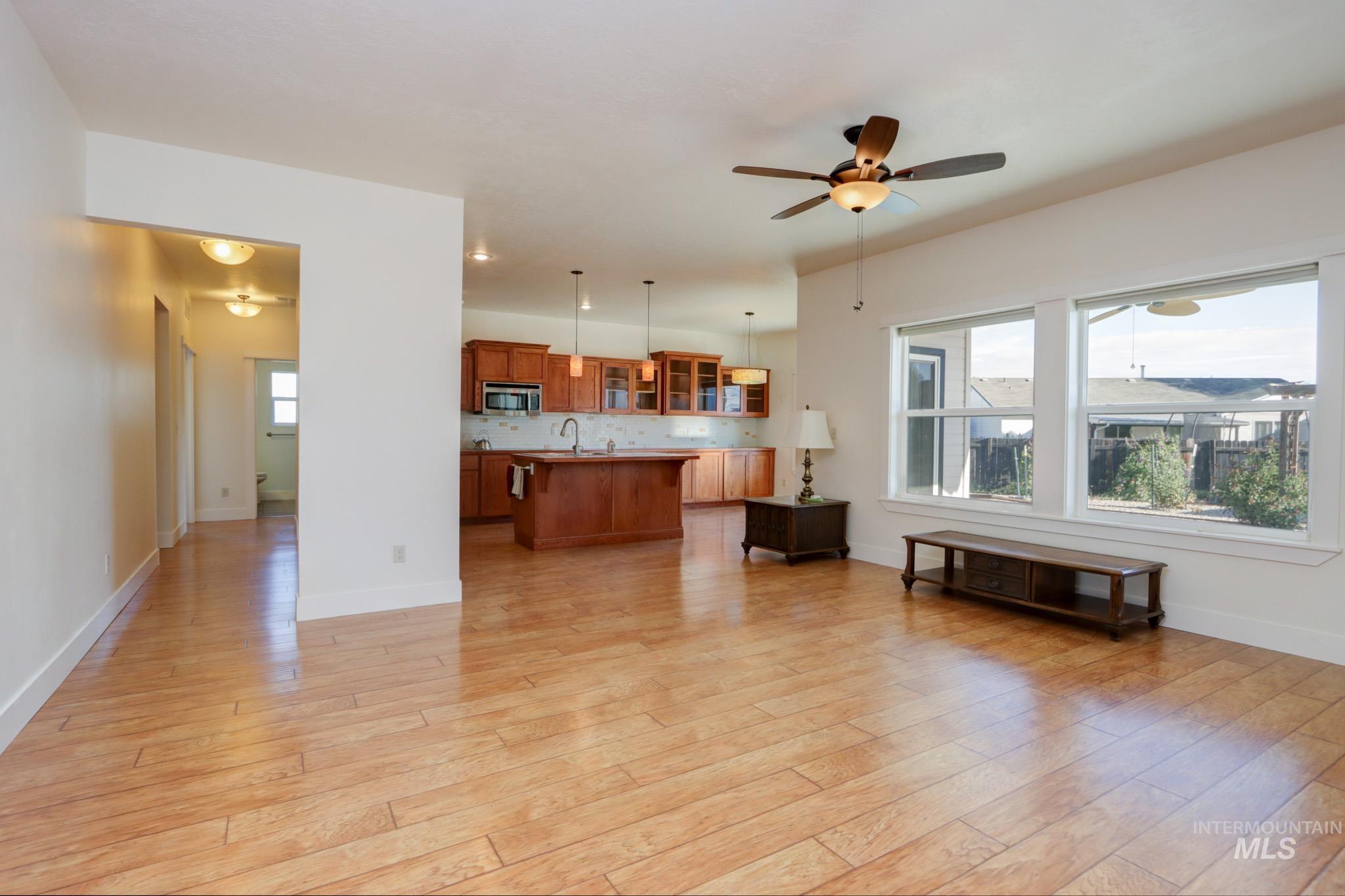 Living room featuring a ceiling fan and light wood-style floors