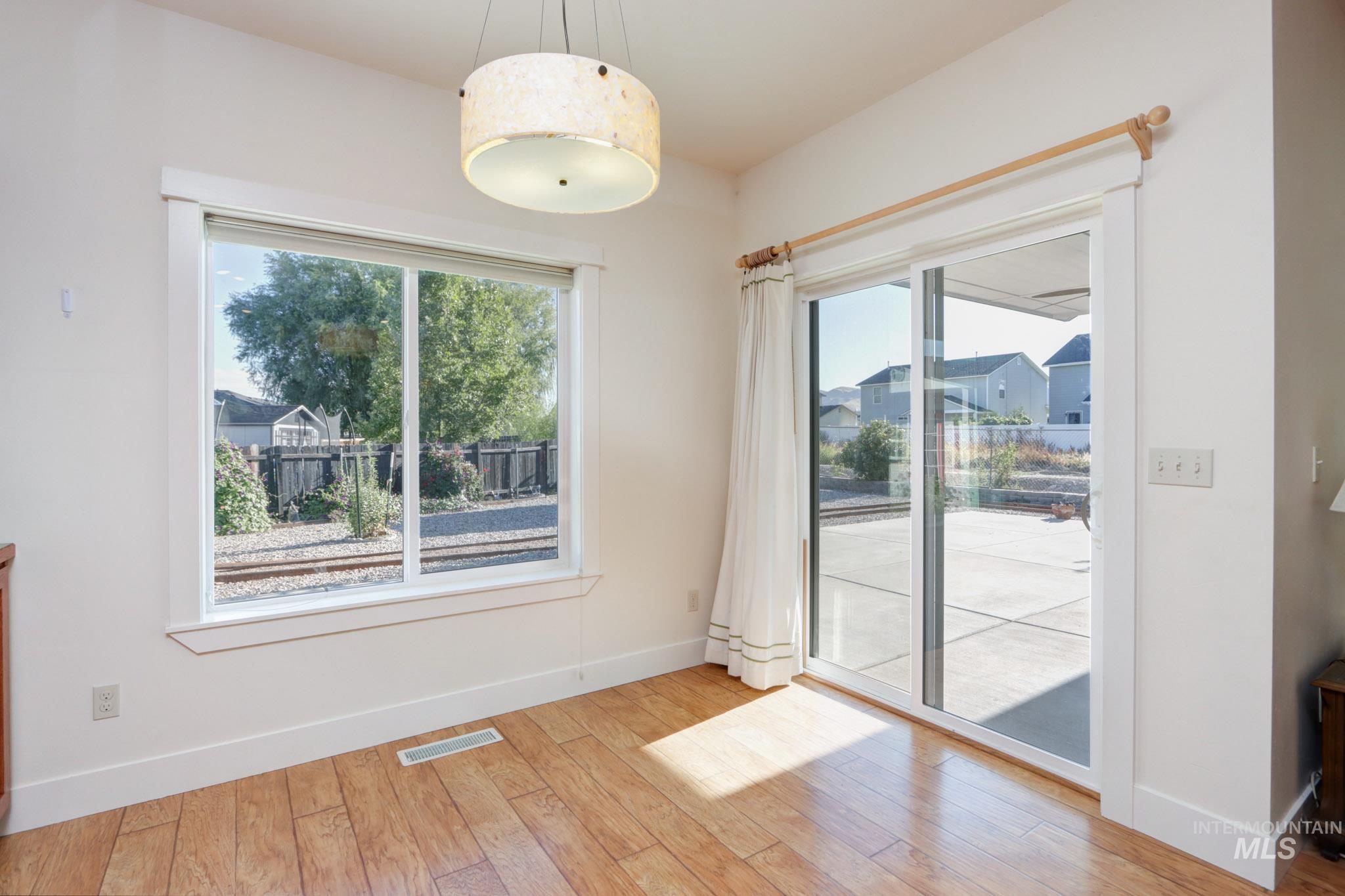 Unfurnished dining area with light wood-style flooring and healthy amount of natural light