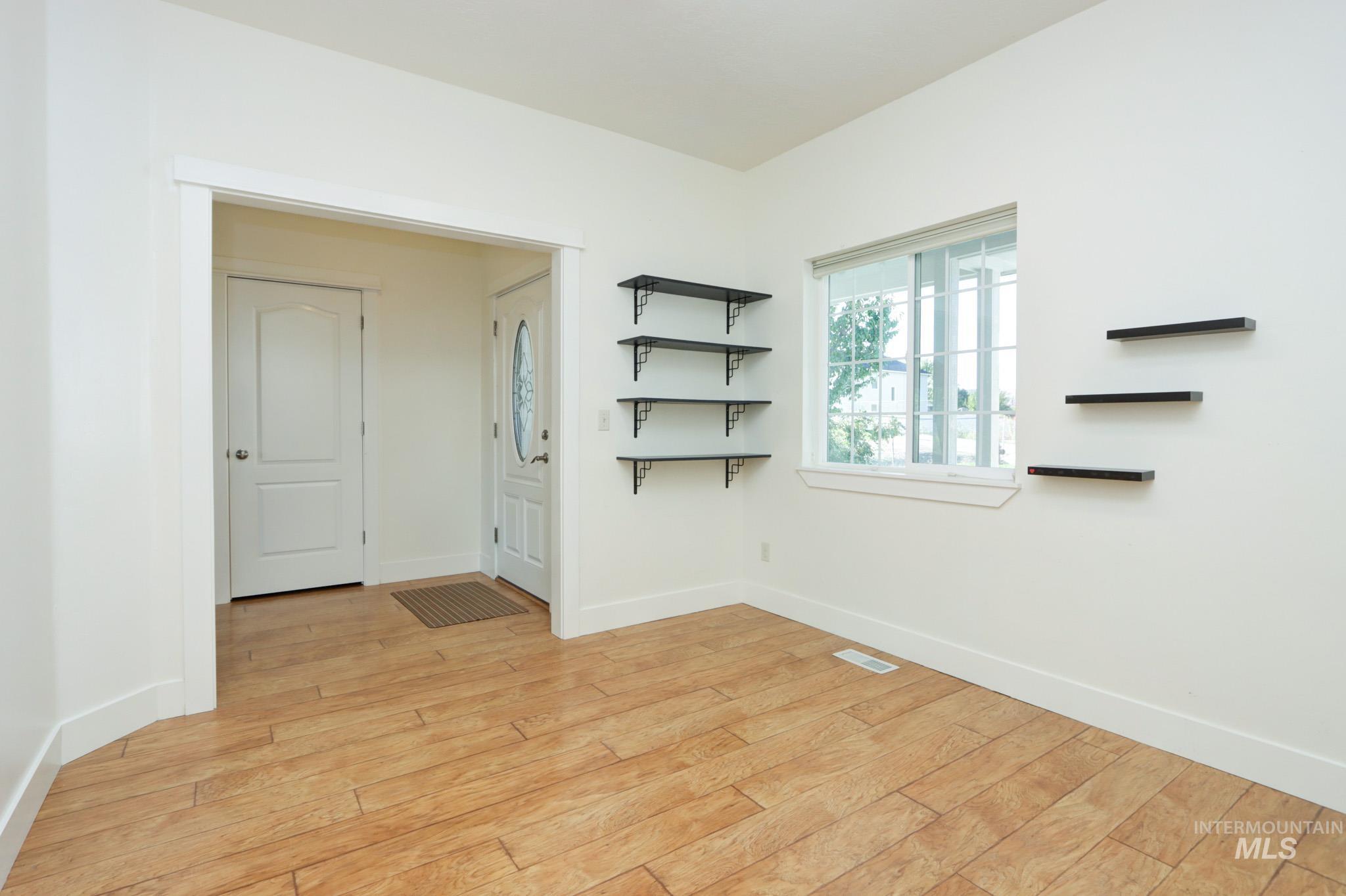 Empty room featuring baseboards and light wood finished floors