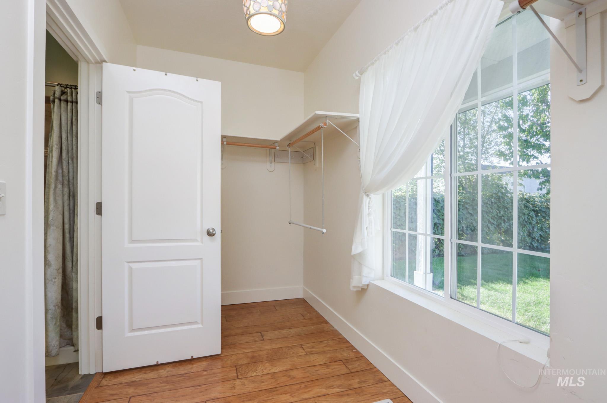 Spacious closet featuring light wood-style flooring