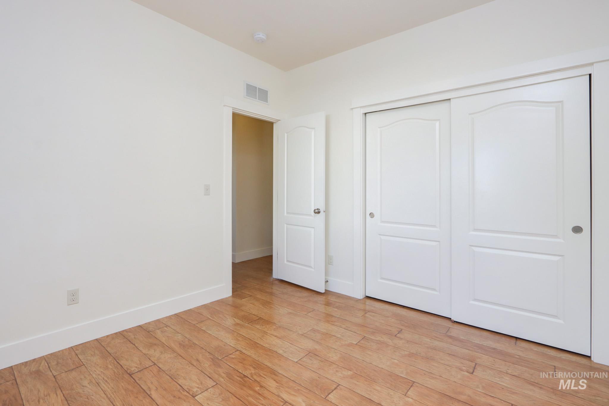 Unfurnished bedroom featuring a closet and light wood finished floors