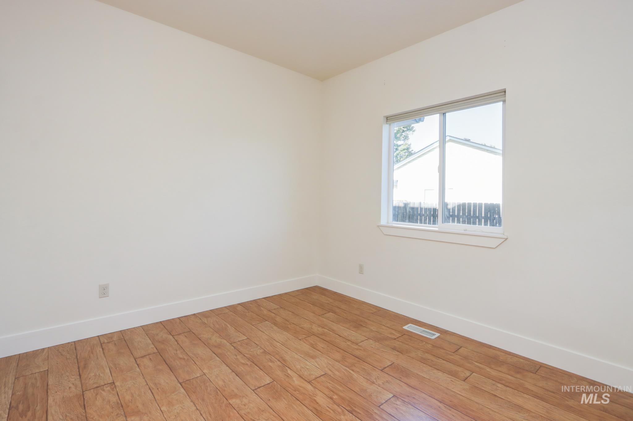 Unfurnished room with baseboards and wood finished floors