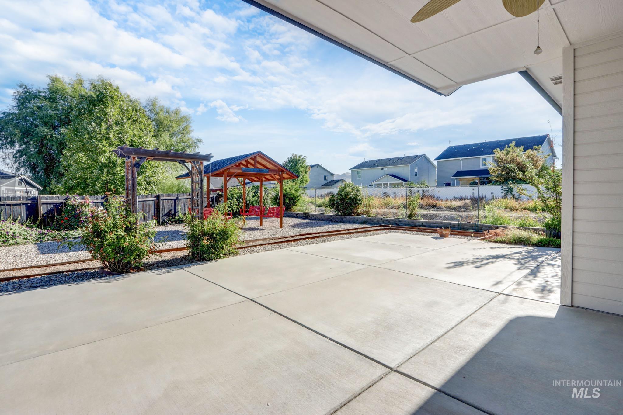 Fenced backyard with a patio and a ceiling fan