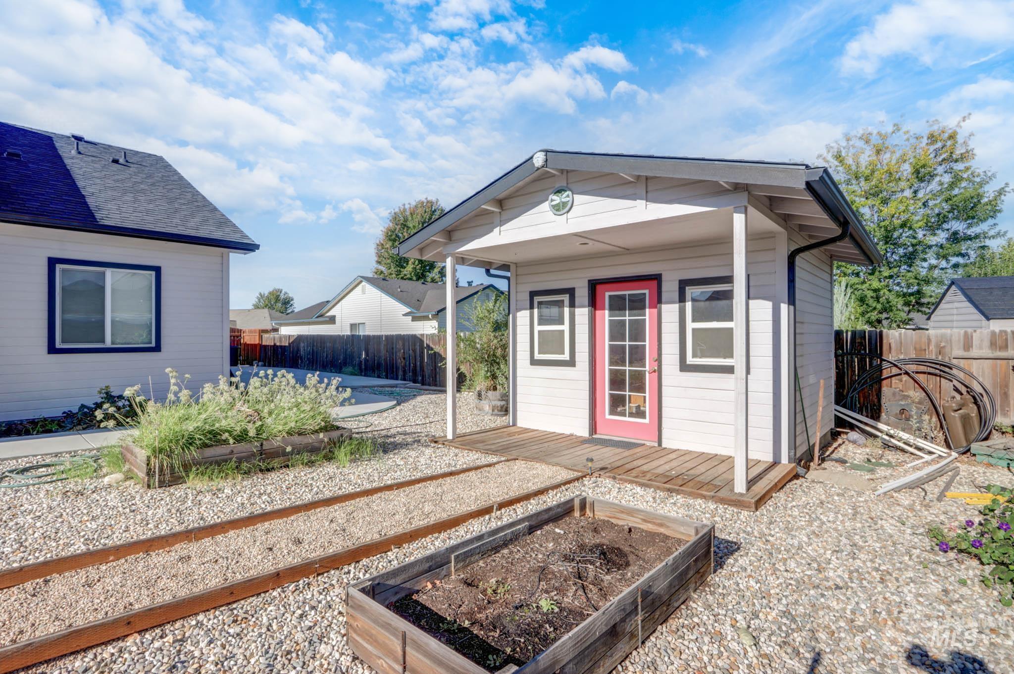 View of outdoor structure with a vegetable garden and a fenced backyard