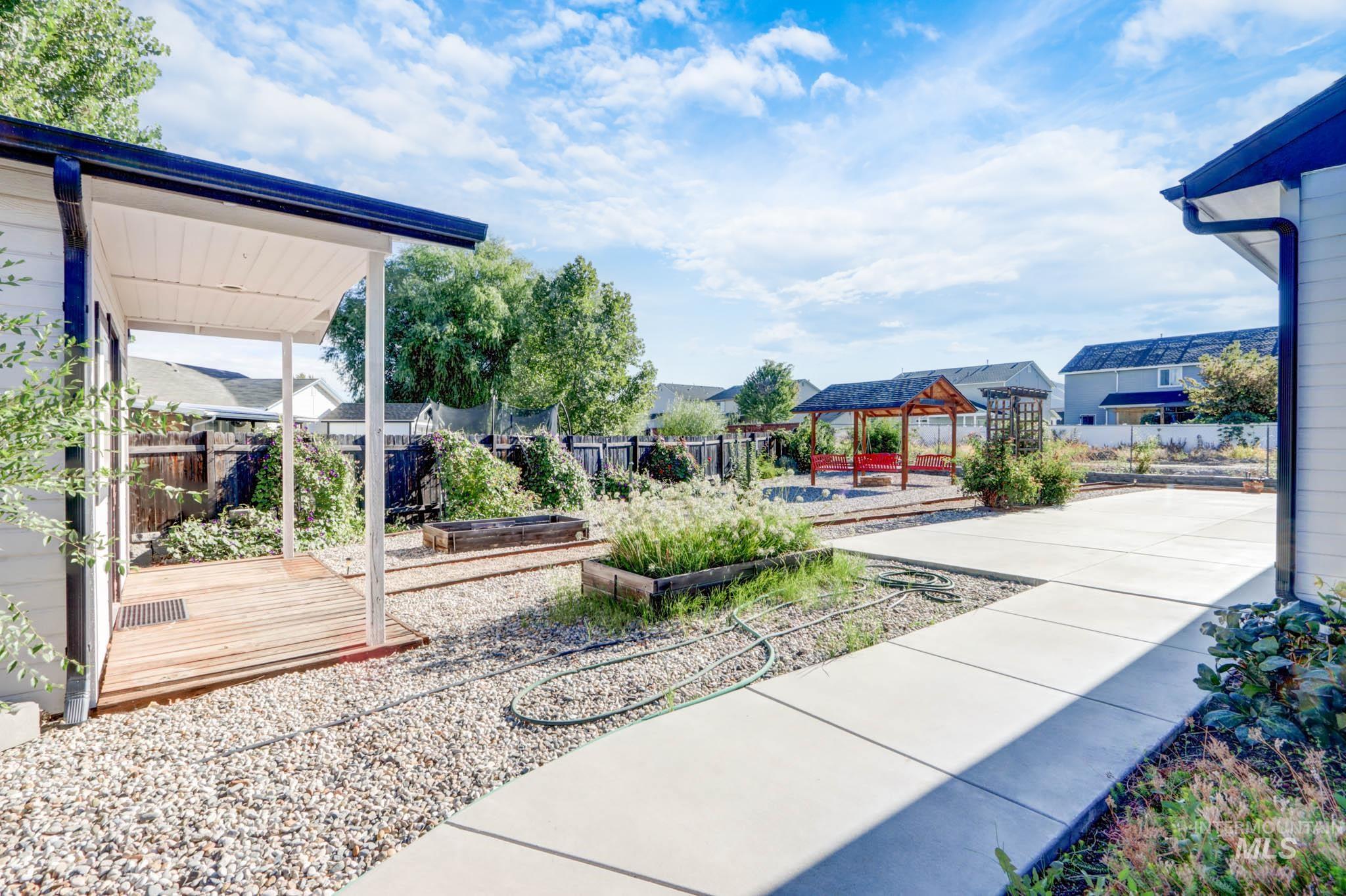 Surrounding community with a vegetable garden, a fenced backyard, a patio, and a pool
