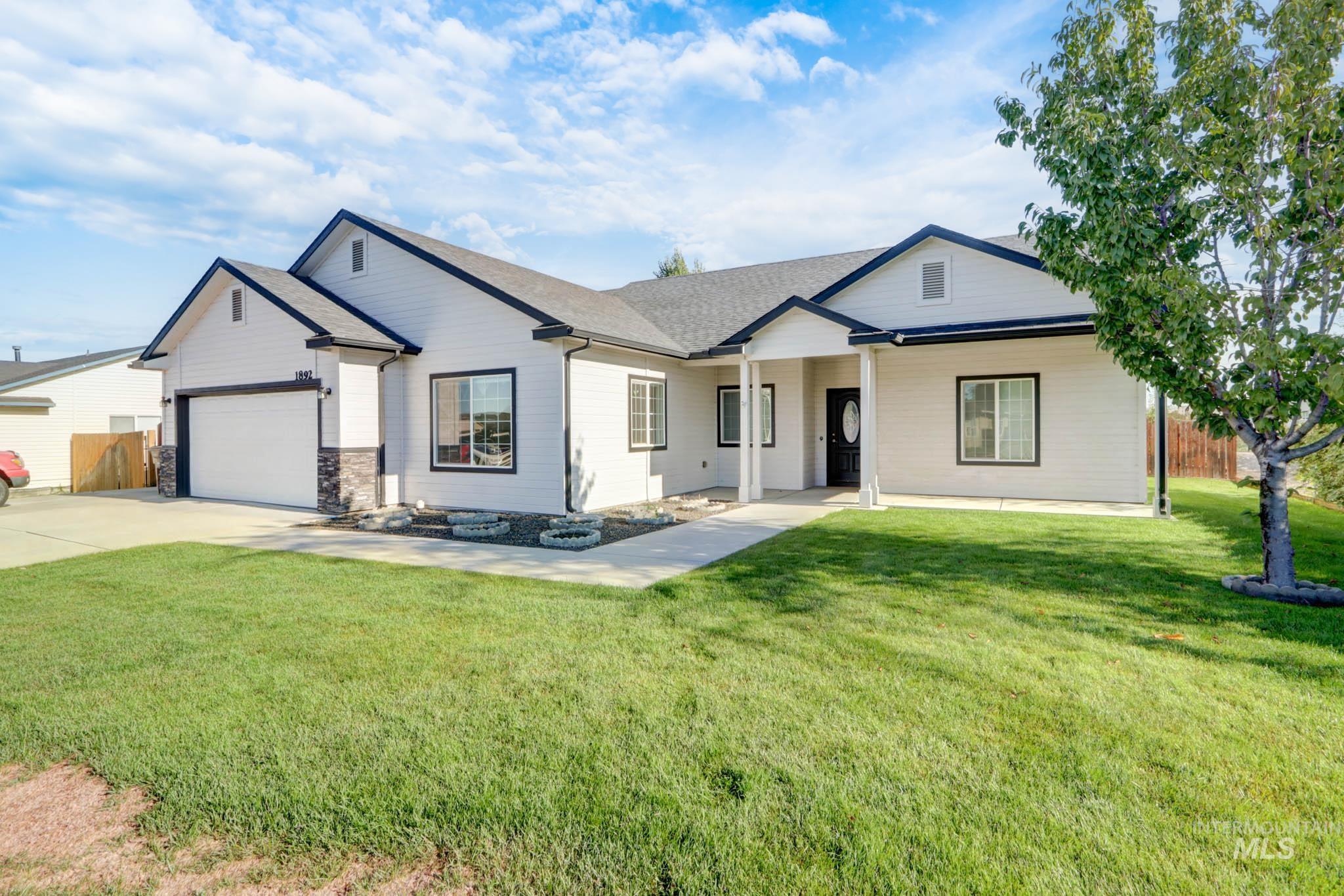 View of front of home with concrete driveway, roof with shingles, a garage, and stone siding