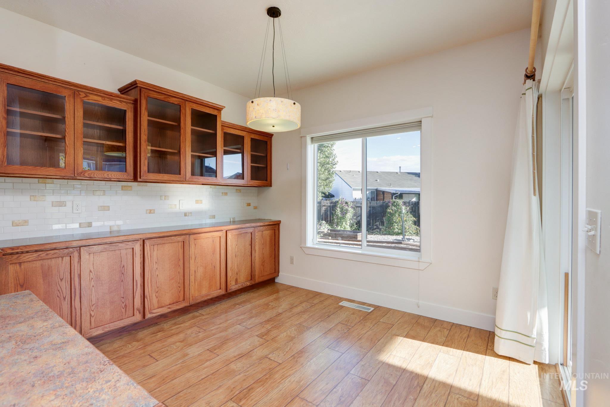 Unfurnished dining area with baseboards and light wood-style flooring