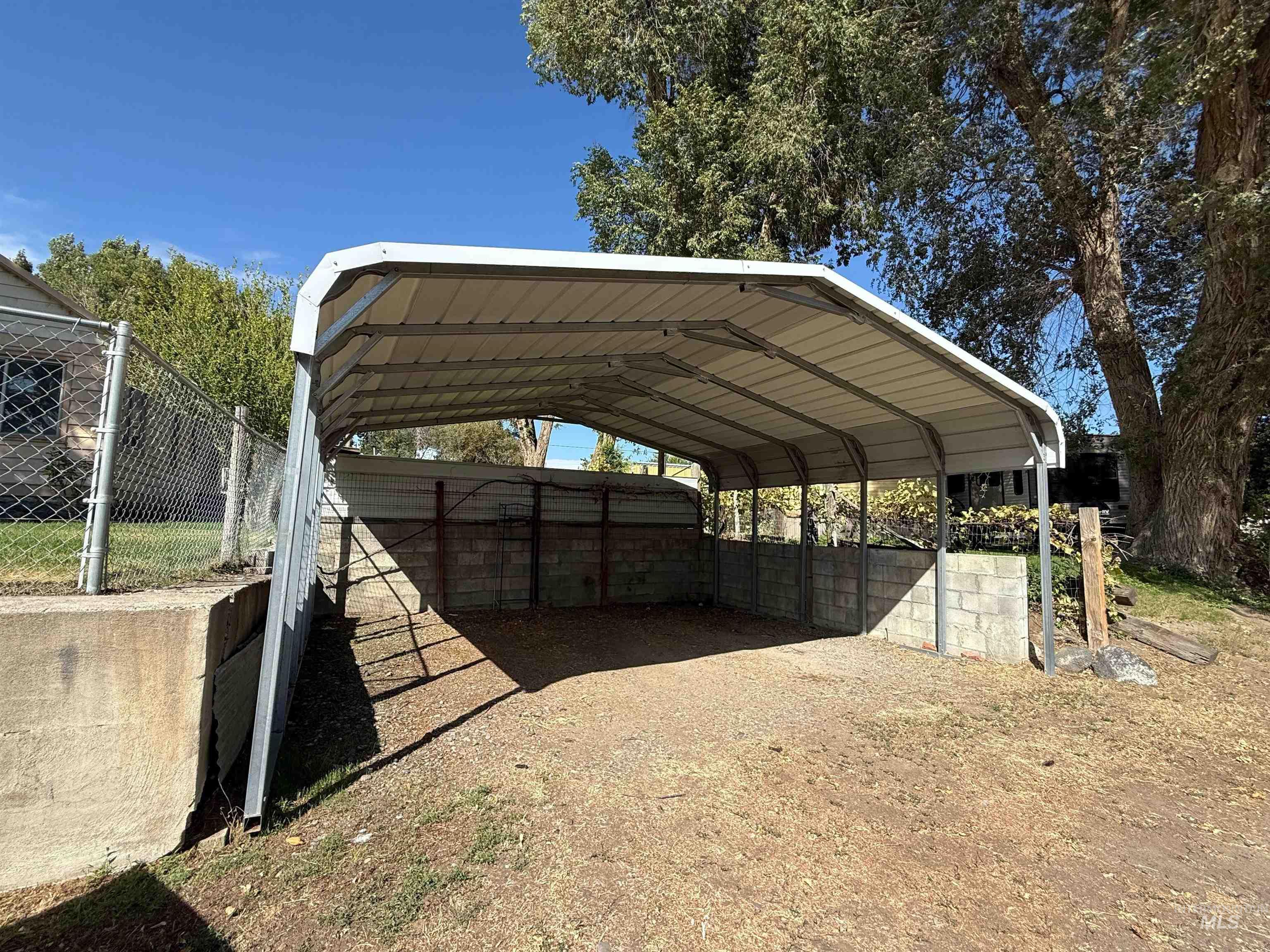 View of parking / parking lot featuring a carport and driveway