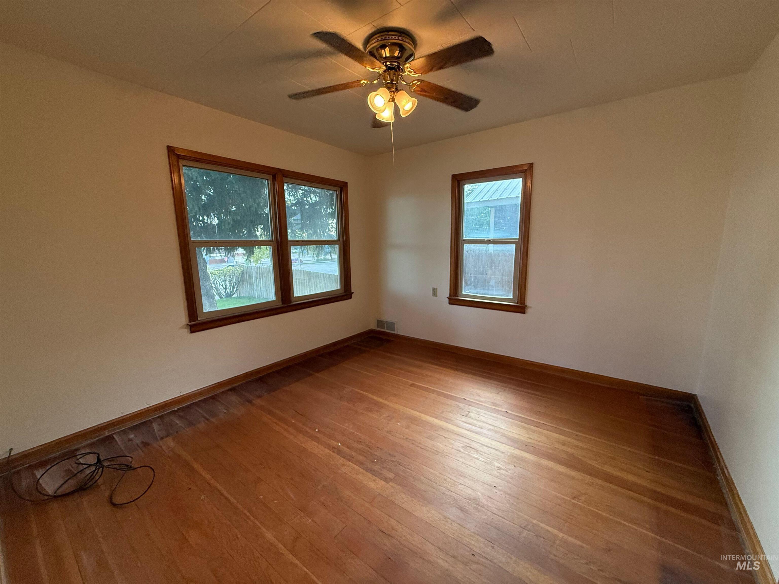 Spare room with light wood finished floors and ceiling fan