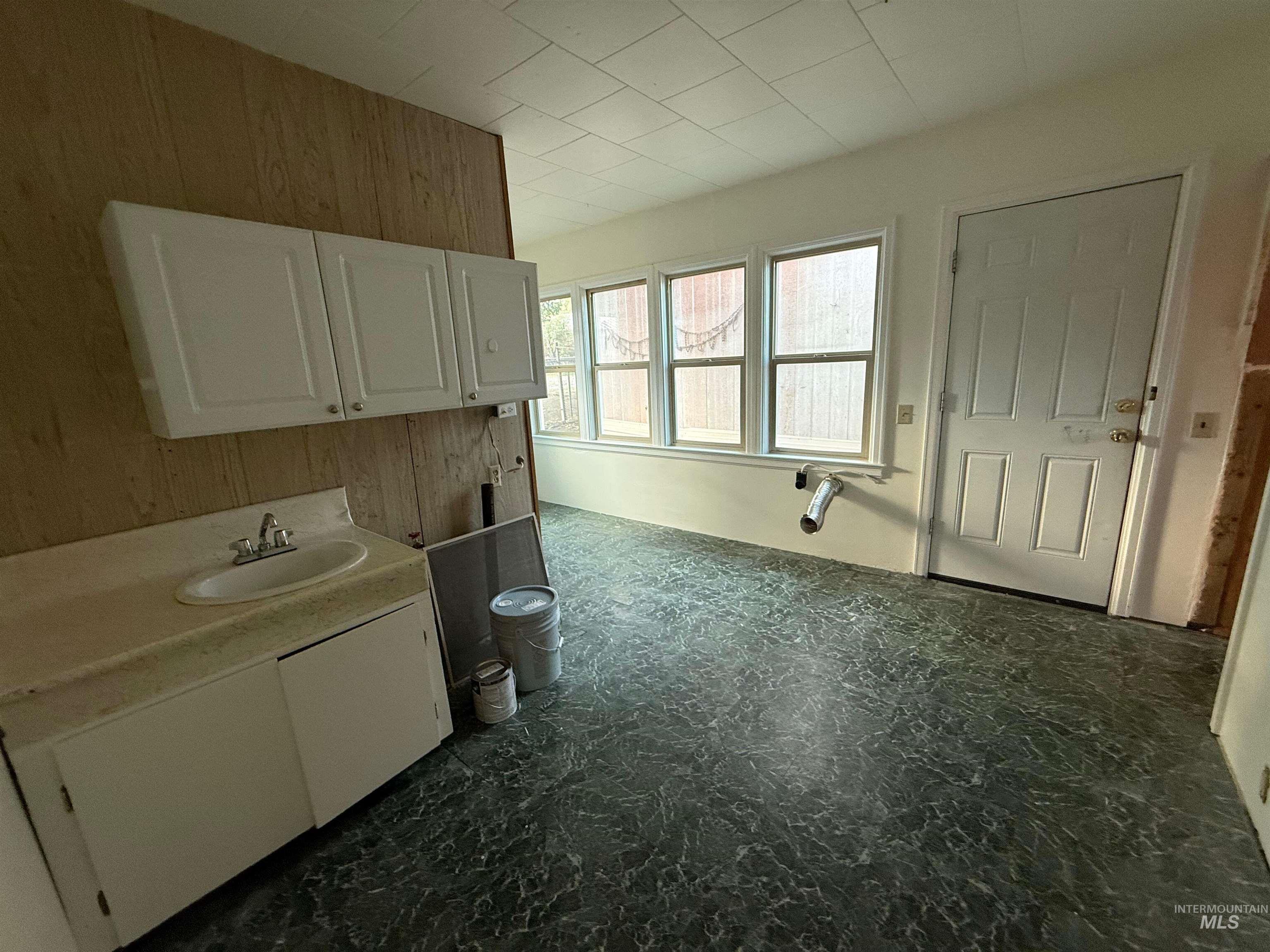 Washroom with wood walls and a sink
