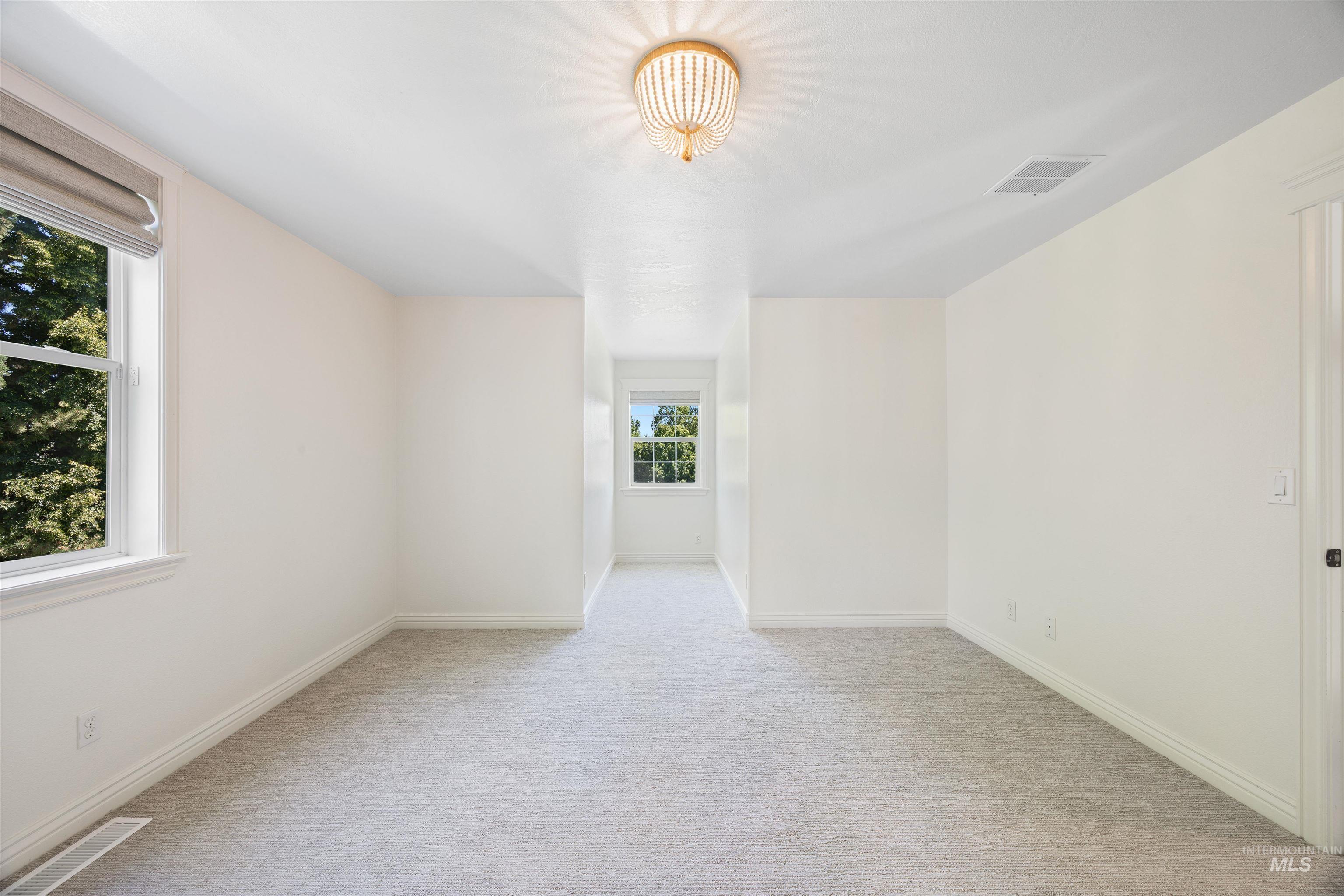 Unfurnished room with light carpet and baseboards
