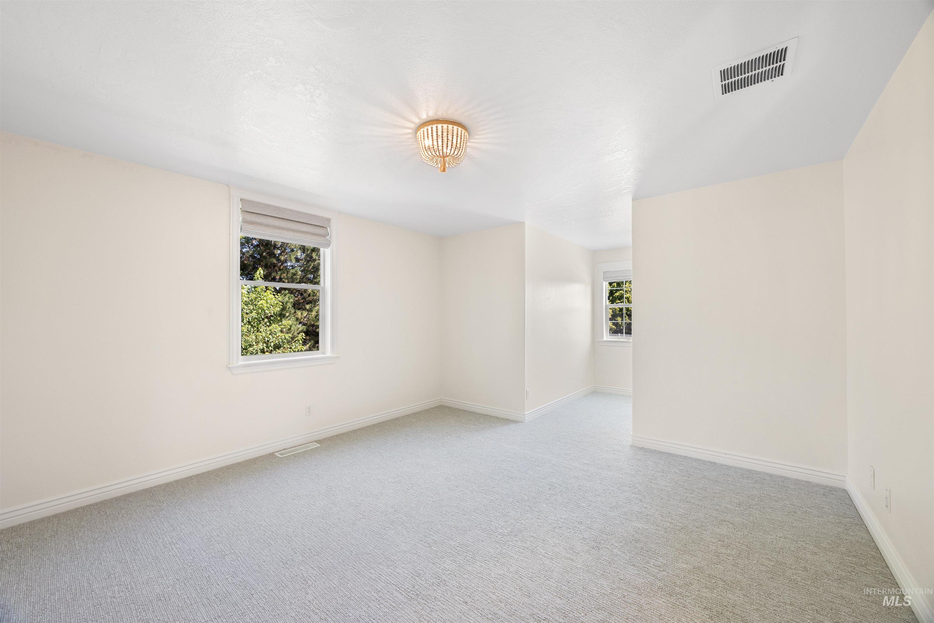 Unfurnished room featuring plenty of natural light and light colored carpet