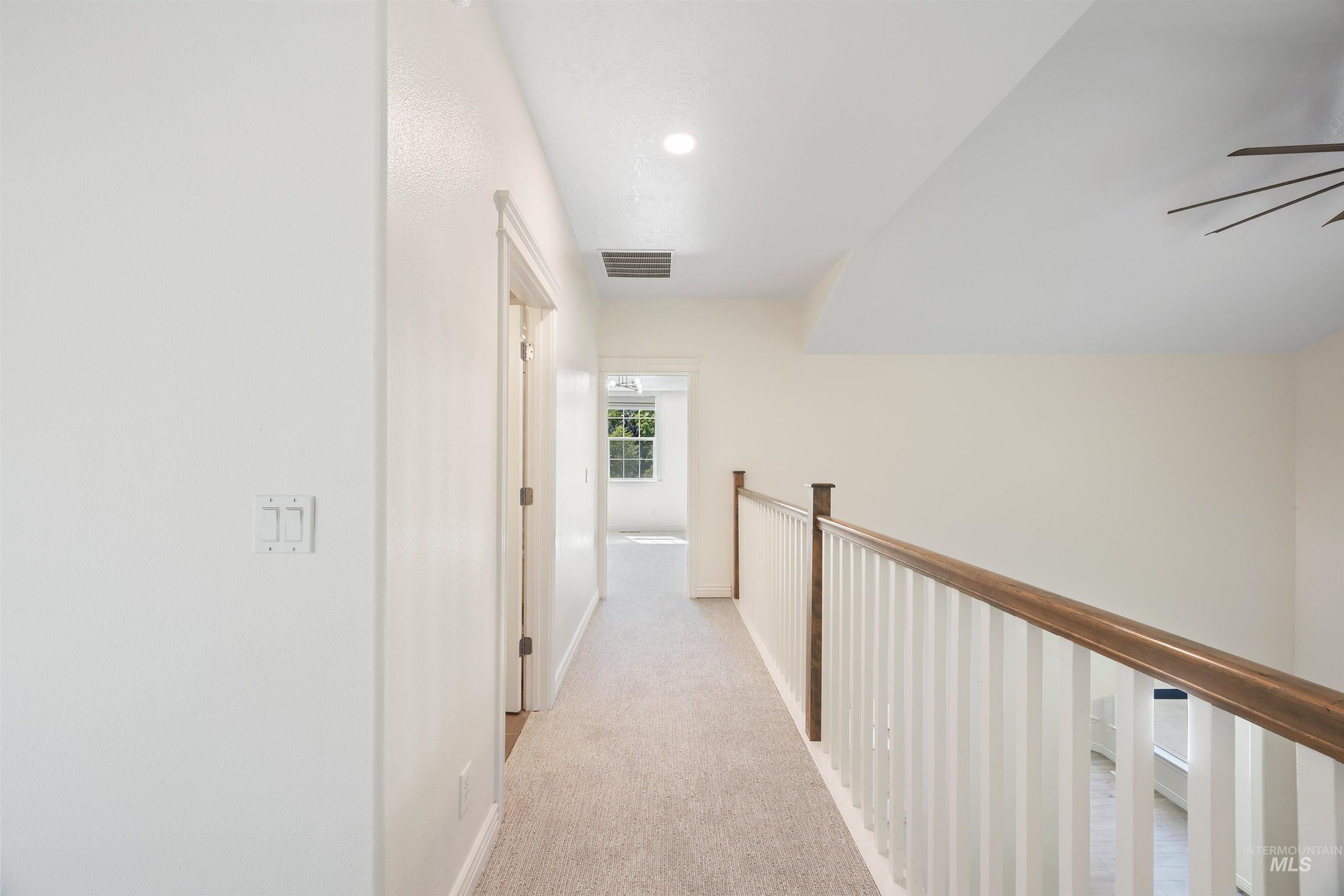 Hallway featuring light carpet and recessed lighting