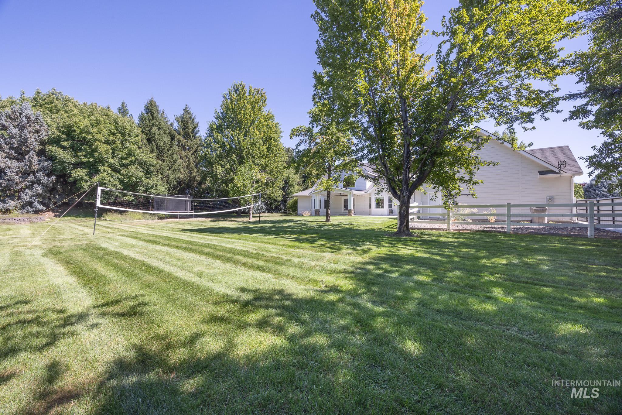 View of community with a lawn and volleyball court