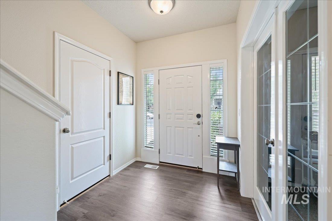 Foyer entrance featuring dark wood-style floors and french doors