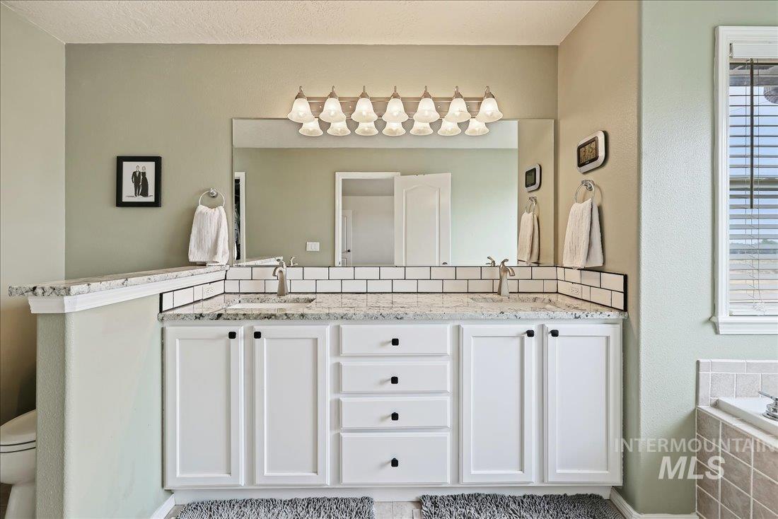 Full bath with double vanity and a garden tub